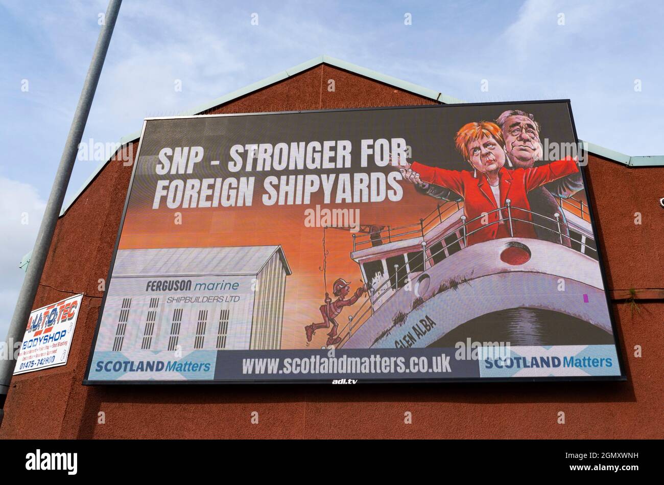 Port Glasgow, Scozia, Regno Unito. 21 settembre 2021. Il gruppo pro UK Union Scotland Matters ha eretto un cartellone fuori dal cantiere Ferguson a Port Glasgow critico per la decisione del governo scozzese di ordinare i futuri traghetti scozzesi con un breve elenco di tre iarde, in Turchia, Polonia o Romania. Il cartellone presenta il leader della SNP e il primo Ministro Nicola Sturgeon e l'ex primo Ministro Alex Salmond in piedi sul prua della linea Titanic con messaggio SNP più forte per i cantieri navali stranieri. Iain Masterton/Alamy Live News. Foto Stock