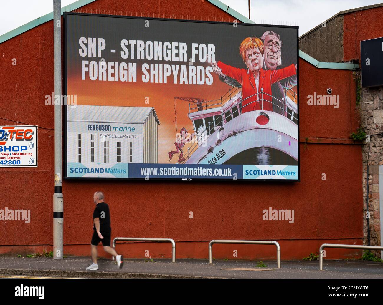 Port Glasgow, Scozia, Regno Unito. 21 settembre 2021. Il gruppo pro UK Union Scotland Matters ha eretto un cartellone fuori dal cantiere Ferguson a Port Glasgow critico per la decisione del governo scozzese di ordinare i futuri traghetti scozzesi con un breve elenco di tre iarde, in Turchia, Polonia o Romania. Il cartellone presenta il leader della SNP e il primo Ministro Nicola Sturgeon e l'ex primo Ministro Alex Salmond in piedi sul prua della linea Titanic con messaggio SNP più forte per i cantieri navali stranieri. Iain Masterton/Alamy Live News. Foto Stock