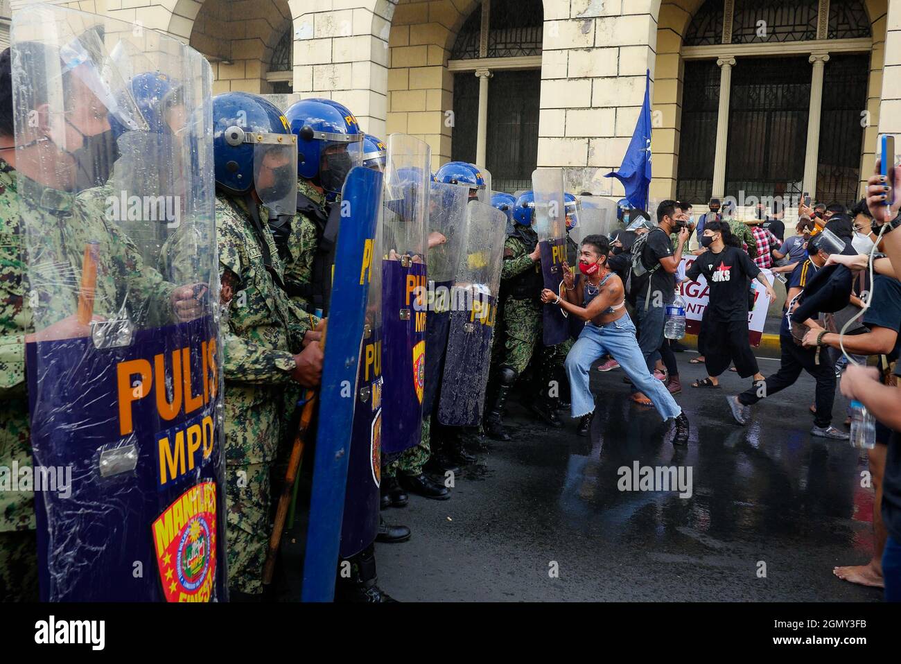 Manila, Regione capitale Nazionale, Filippine. 21 settembre 2021. Una protesta tenuta il giorno in cui la legge marziale è stata dichiarata il 21 settembre 1972. Tuttavia, la polizia di Manila blocca un gruppo di manifestanti diretti al monumento Andres Bonifacio. Si radunarono per la prima volta a Carriedo, a Manila. Poi la polizia blocca e disperdere il gruppo con scudo, bastoni e un canone d'acqua.Un manifestante cerca di spingere un blocco della polizia mentre un cannone d'acqua ha sparato contro di loro. (Credit Image: © George Buid/ZUMA Press Wire) Foto Stock