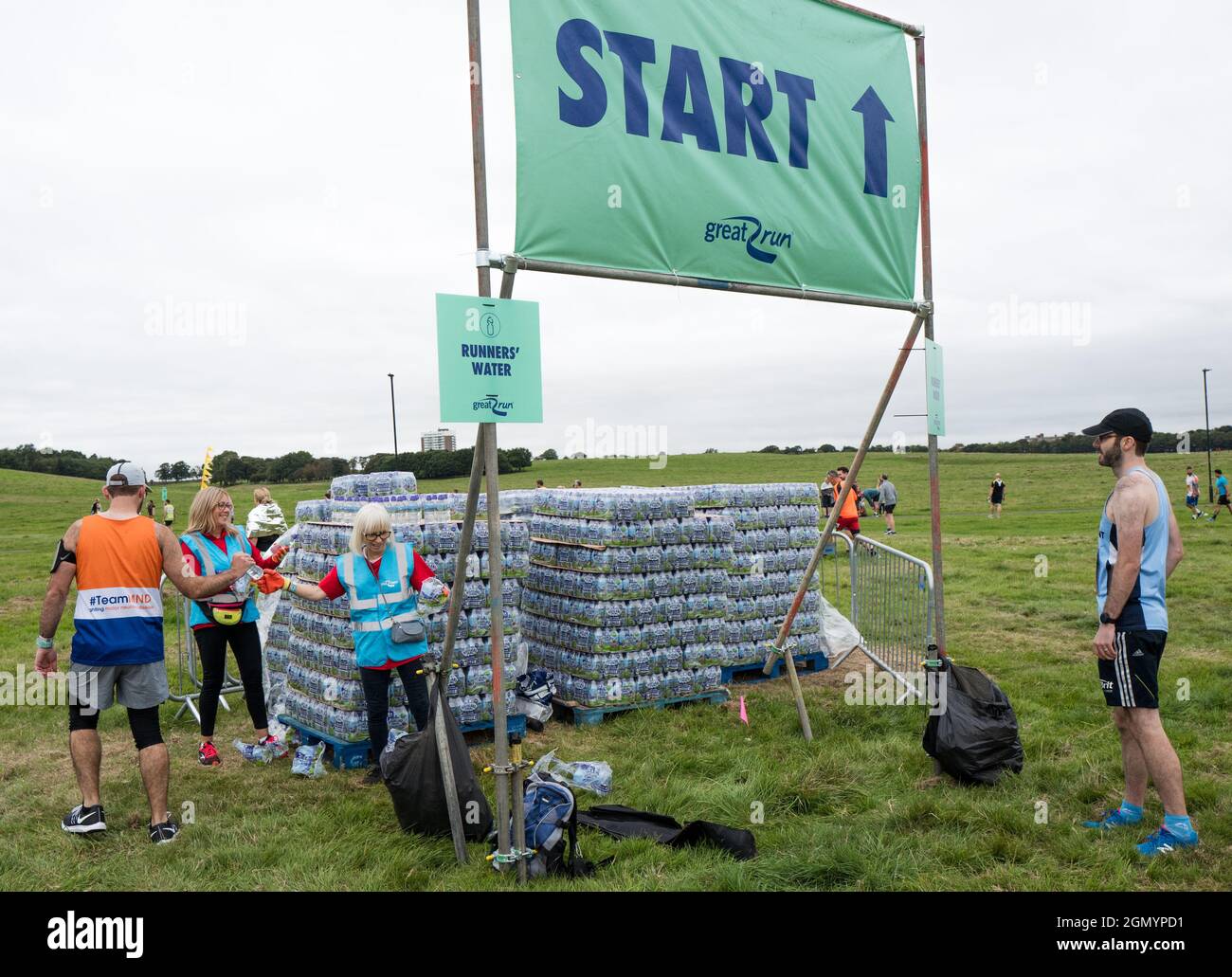 Volontari che consegnano bottiglie d'acqua gratuite ai concorrenti che partecipano alla Great North Run 2021. Foto Stock