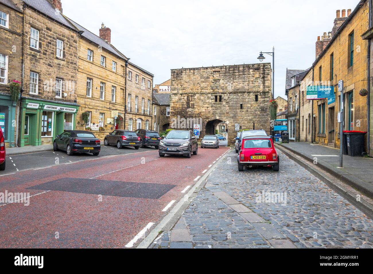 Veicoli che passano attraverso la stretta arcata della Bondgate Tower nella città di Northumberland di Alnwick. Foto Stock