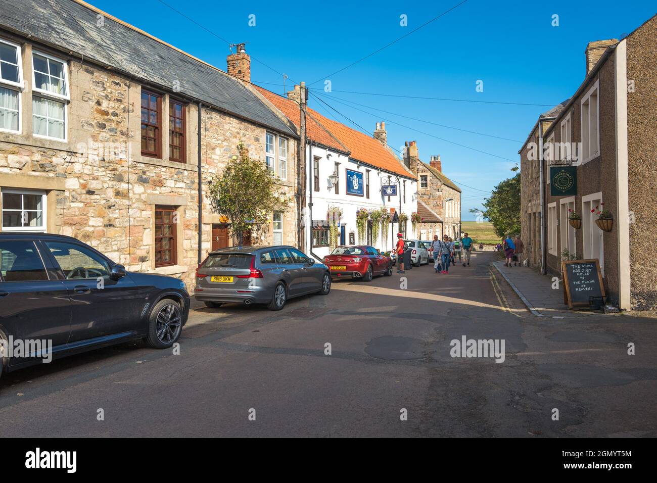 Giro turistico a piedi lungo la strada del Castello sull'Isola Santa di Lindisfarne, Northumberland, Inghilterra. Foto Stock