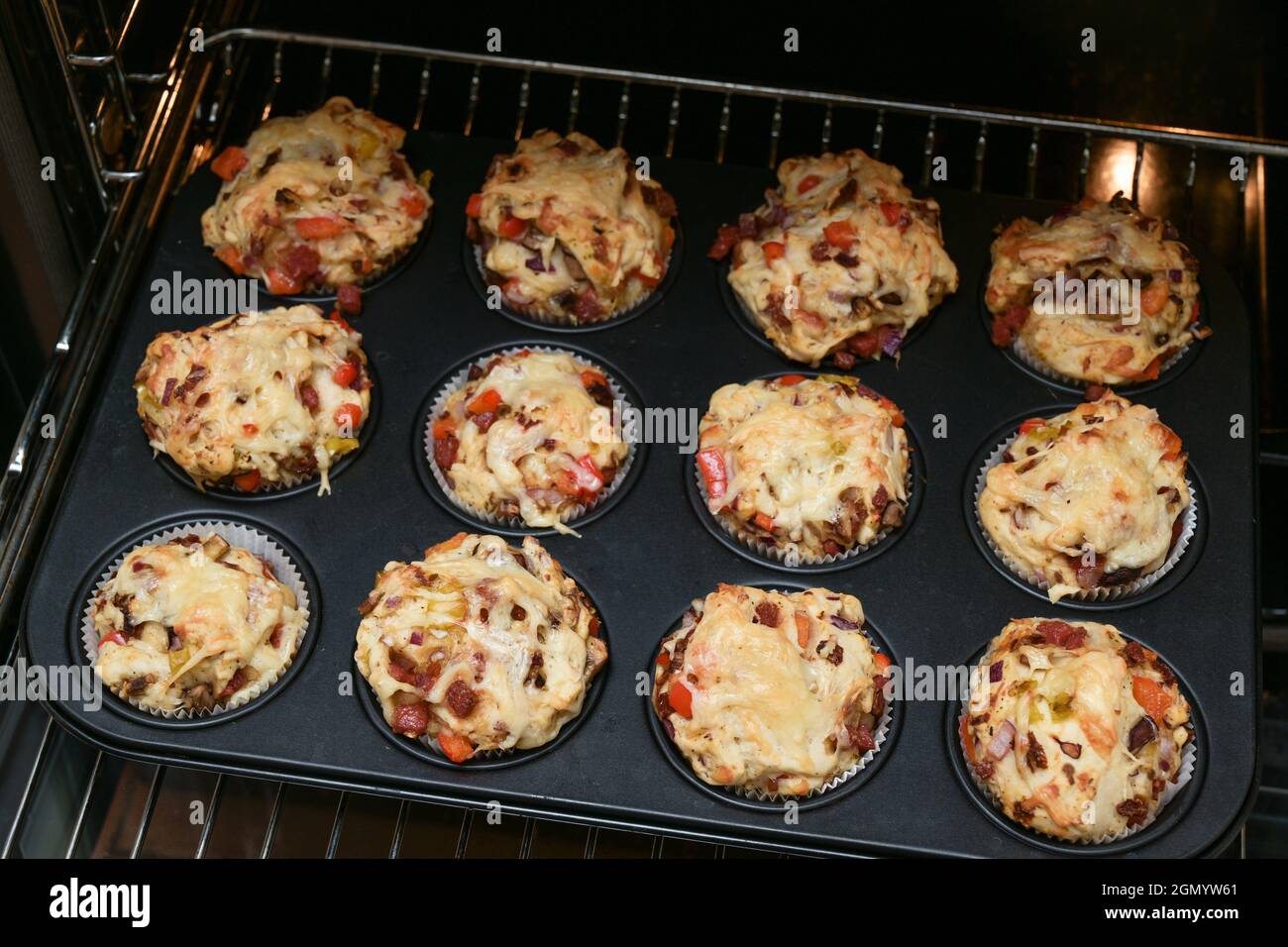 Vassoio da forno con muffin fatti in casa per pizza su una griglia nel forno, fuoco selezionato, profondità di campo stretta Foto Stock