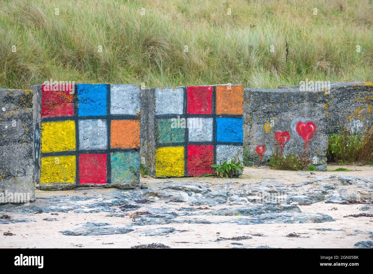 Grandi blocchi di cemento usati come difesa anticarro della seconda guerra mondiale dipinte come morsi o cubi rubik. Foto Stock