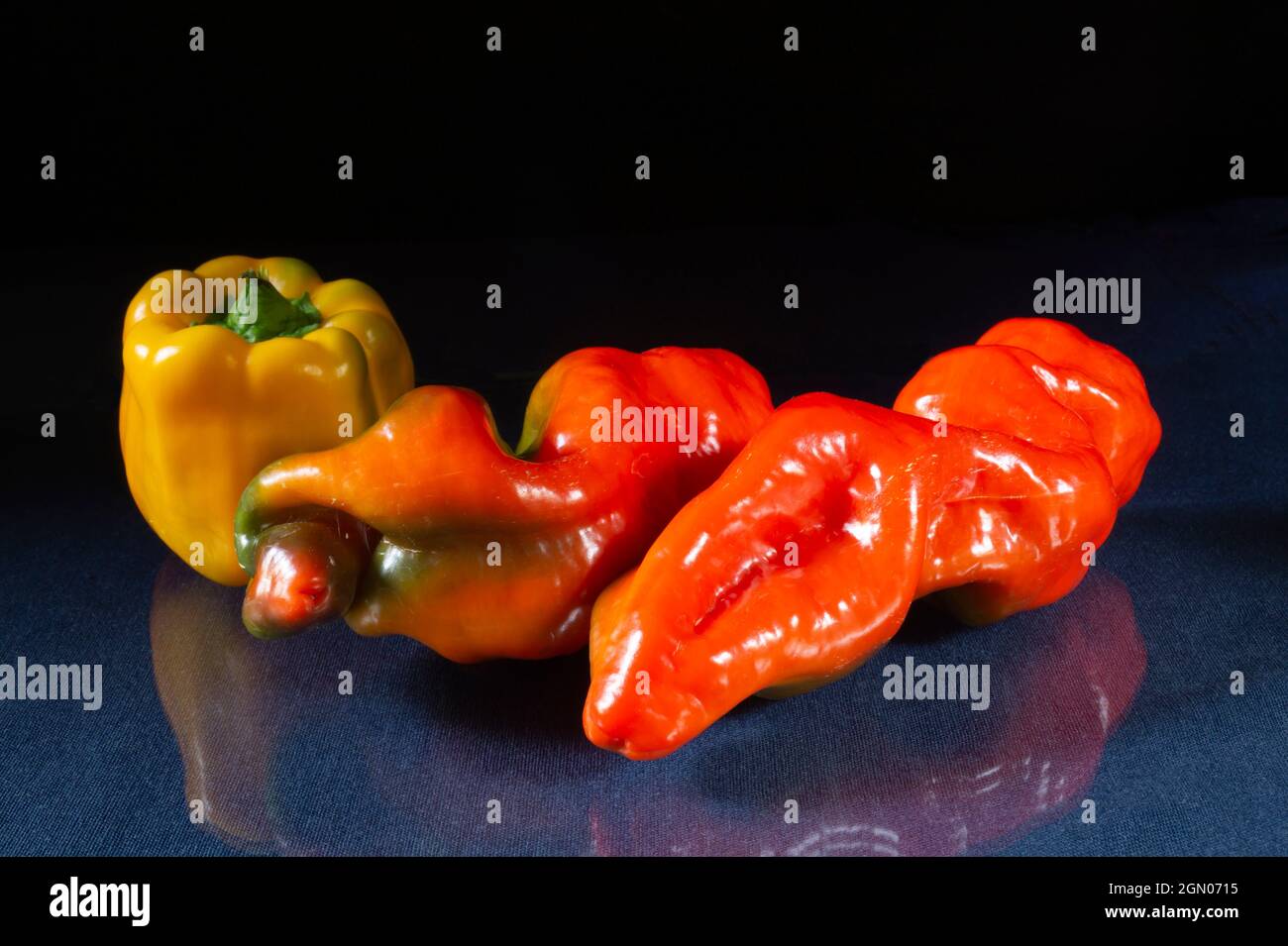 Pepe rosso sul tavolo con un riflesso. Prodotti alimentari su sfondo nero Foto Stock