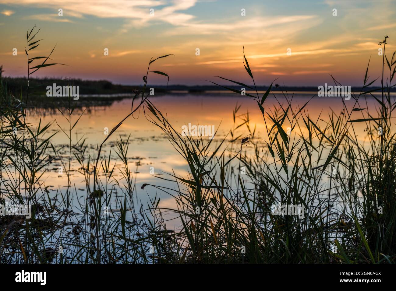 Romantico tramonto che brilla crepuscolo sul lago Foto Stock