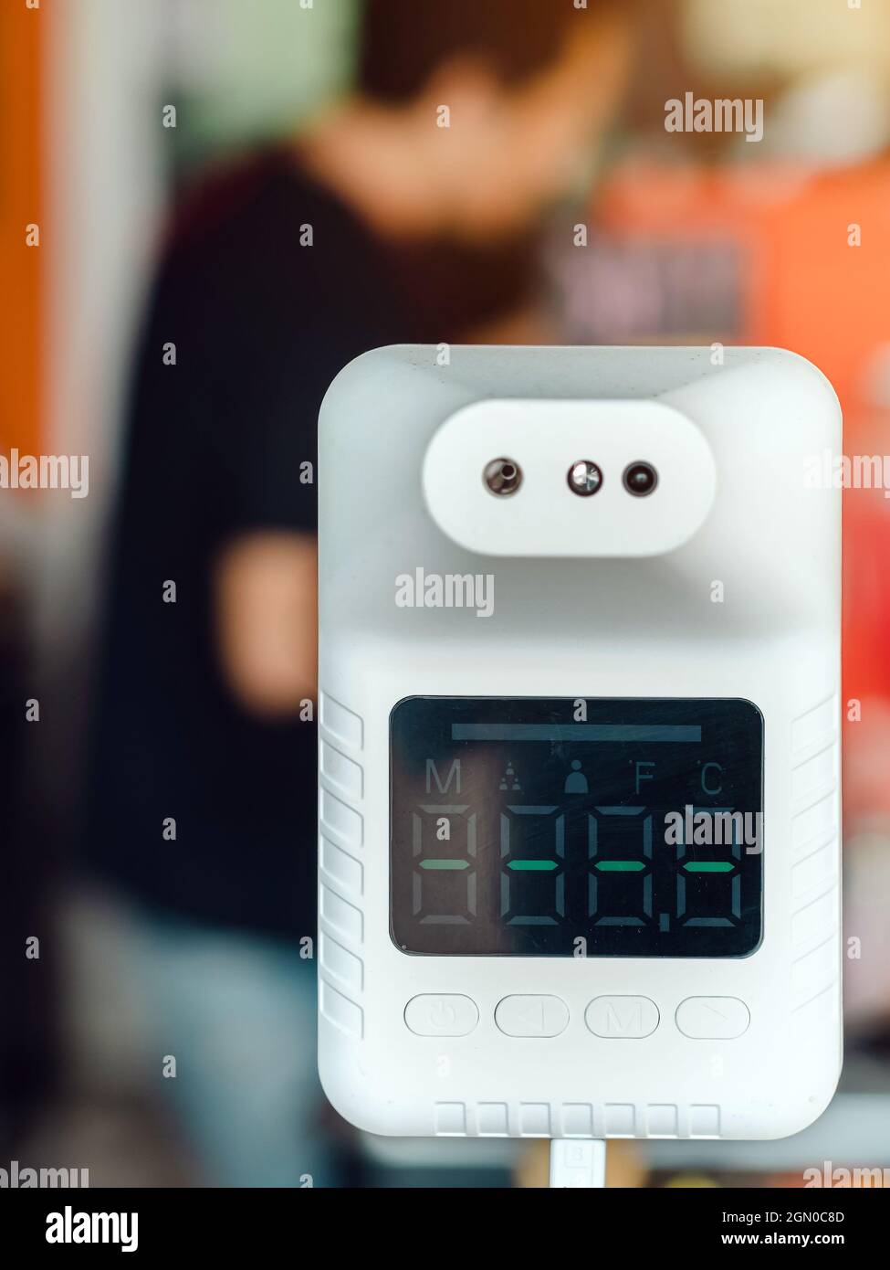 Macchina digitale per la misurazione automatica della temperatura corporea,  per la misurazione della temperatura corporea, posizionando una mano sul  sensore in una caffetteria per l'uso obbligatorio Foto stock - Alamy