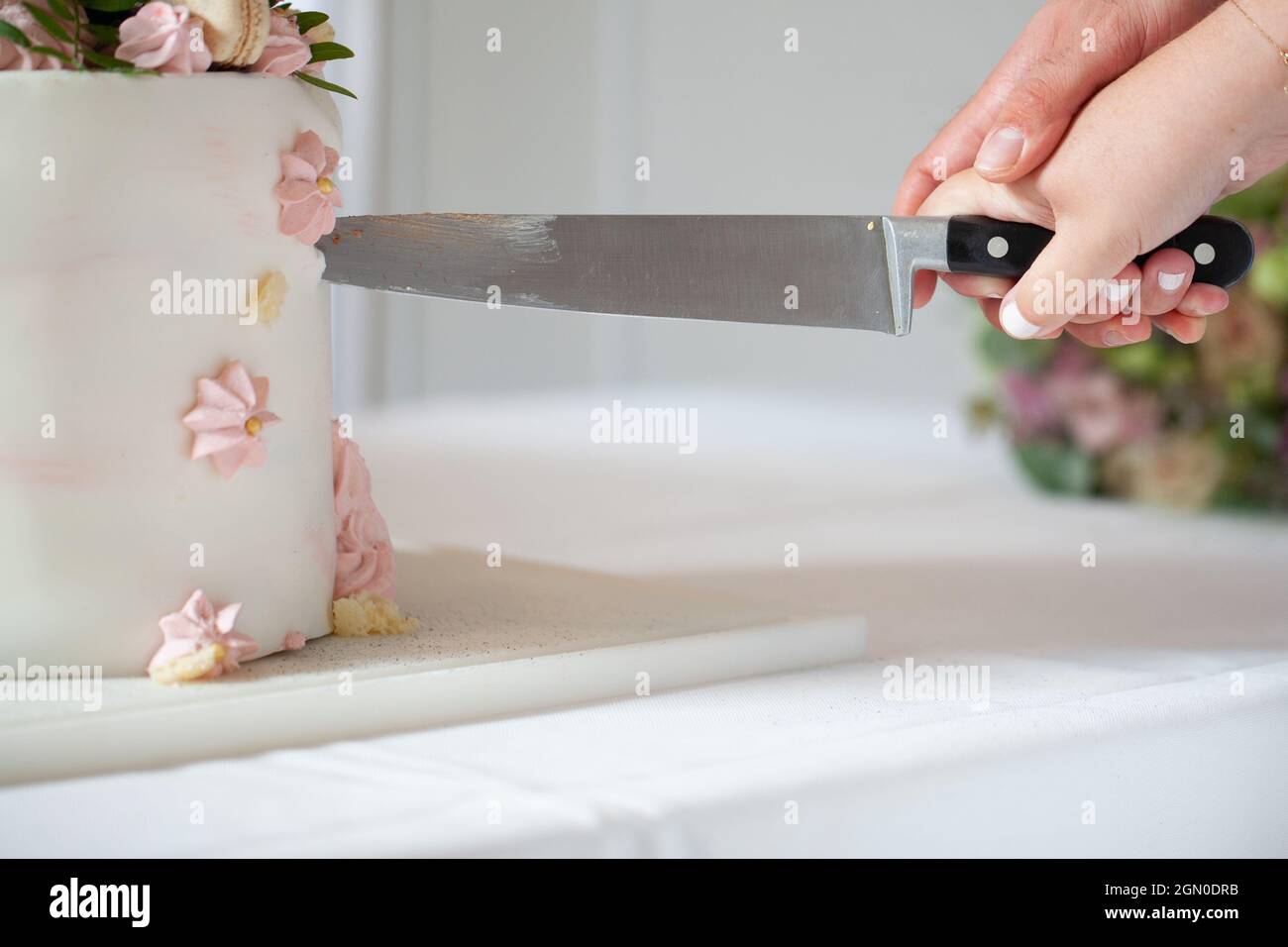 Dettaglio di sposa e sposo taglio torta di nozze dopo essere stato sposato. Foto di alta qualità Foto Stock