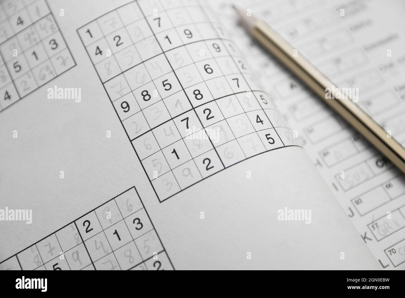 Completato Sudoku puzzle in primo piano in una rivista hobby accanto a una matita gialla e nera Foto Stock