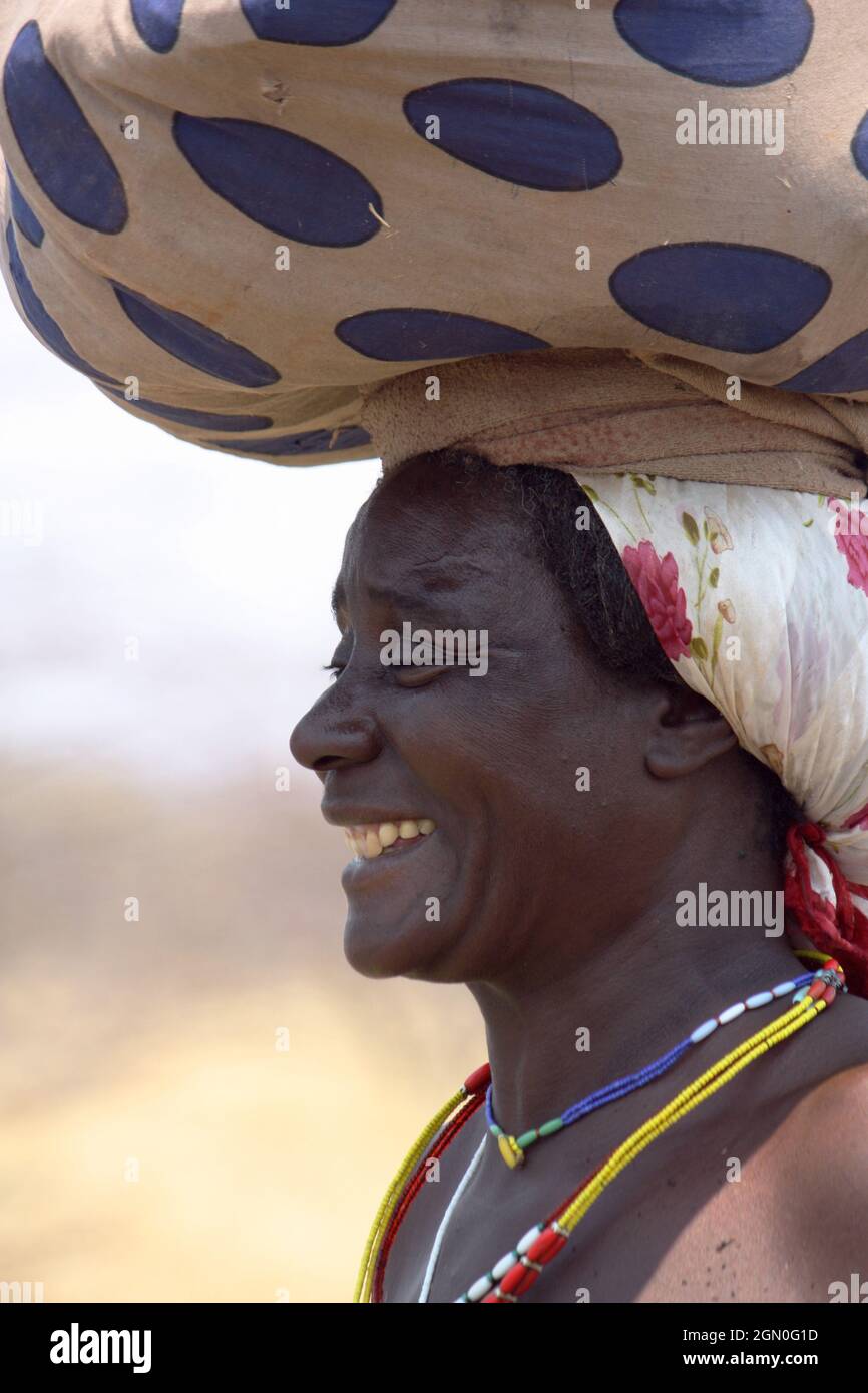 Angola; parte occidentale della provincia di Cunene; donna con bagaglio sulla testa; sulla strada Foto Stock