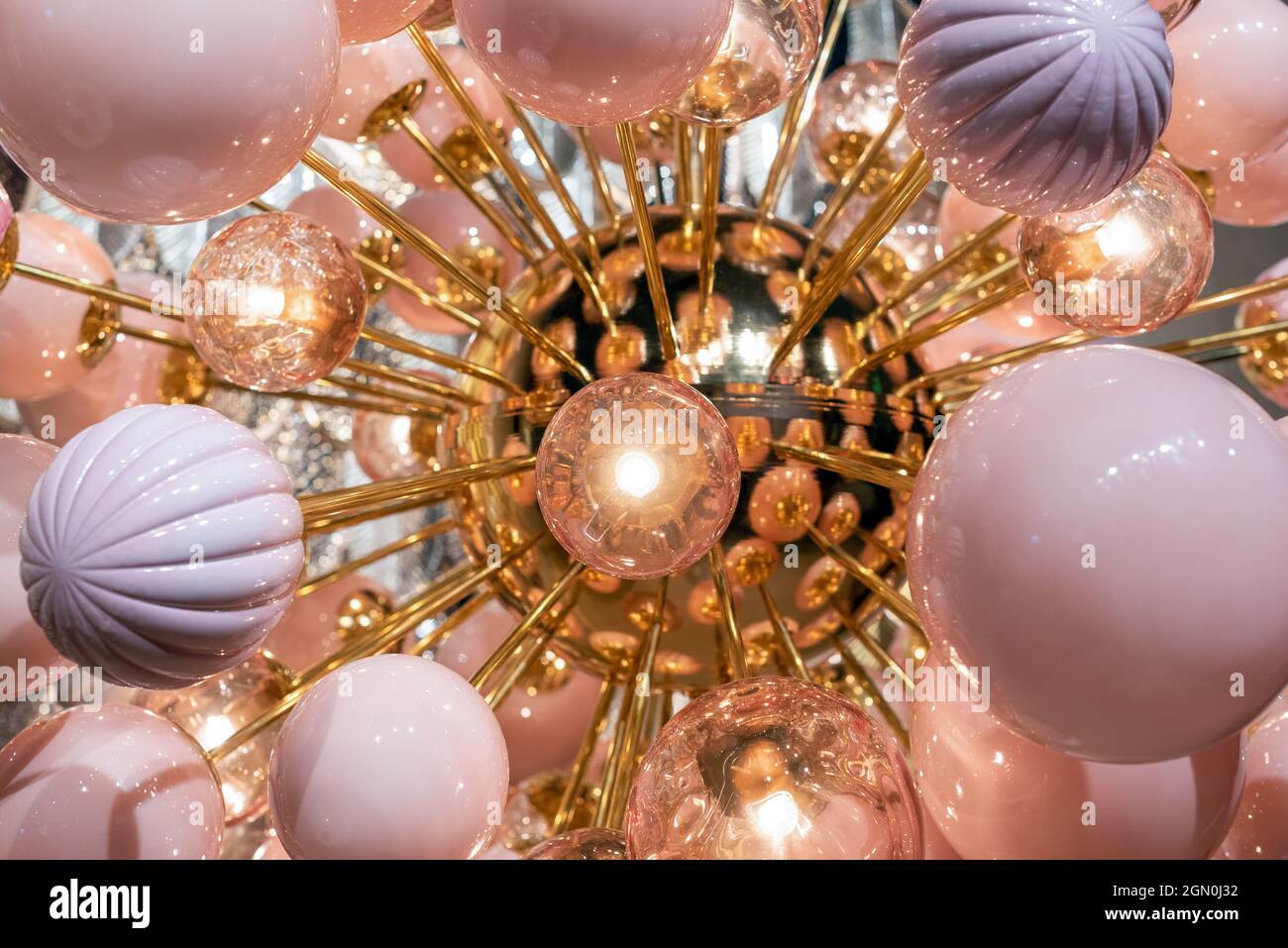 Primo piano di futuristico lampadario con palle lucide e lampadine rotonde che brillano luminosamente Foto Stock