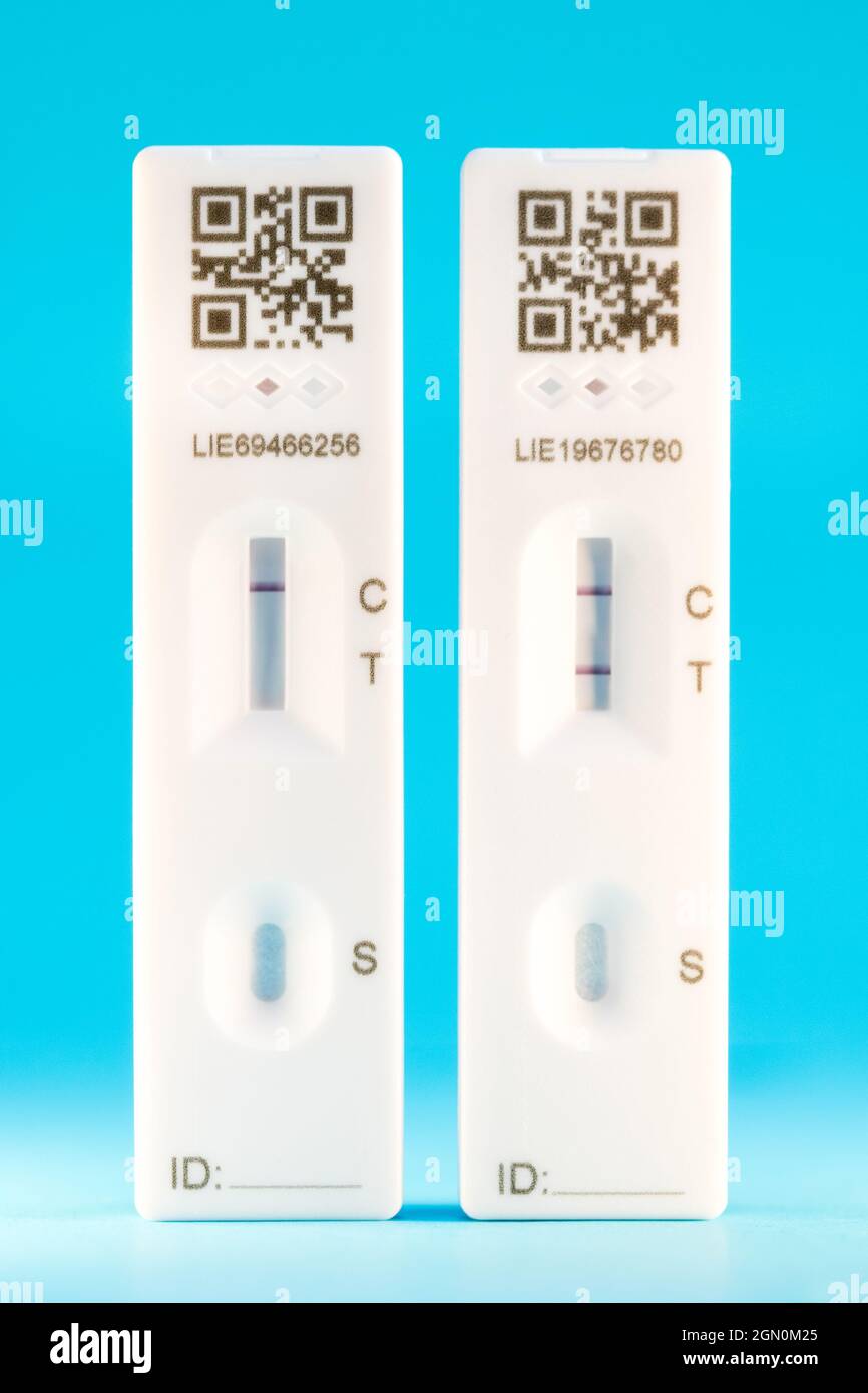 Striscia di prova a flusso laterale che mostra un risultato negativo del test Covid 19 e un risultato positivo simulato. Foto Stock