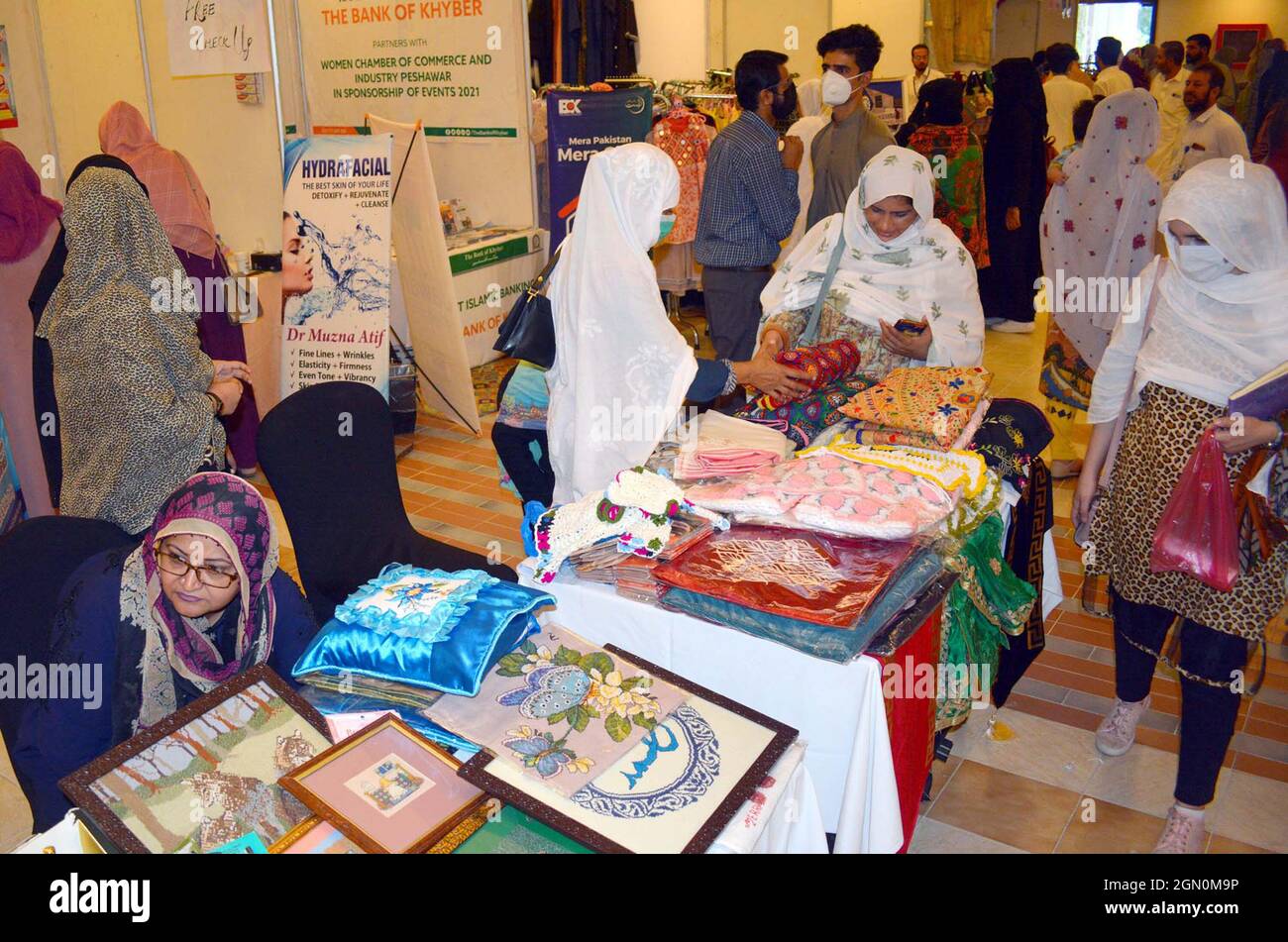 I visitatori si interessano molto alle bancarelle durante il Made in Khyber Pakhtunkhwa Exhibition Expo 2021 organizzato dalla Camera di Commercio e industria delle Donne (WCCI) che si è tenuta a Peshawar martedì 21 settembre 2021. Foto Stock