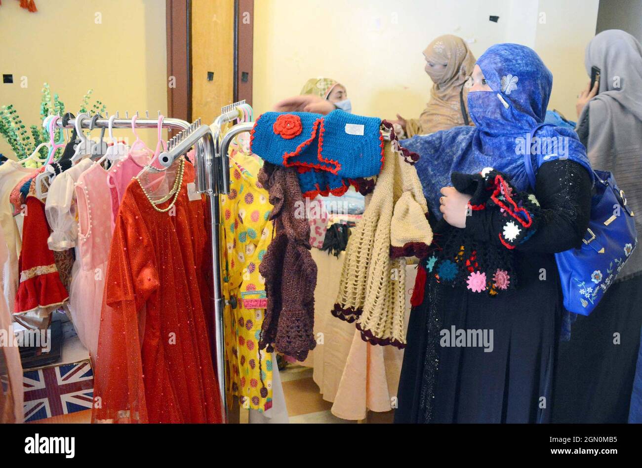 I visitatori si interessano molto alle bancarelle durante il Made in Khyber Pakhtunkhwa Exhibition Expo 2021 organizzato dalla Camera di Commercio e industria delle Donne (WCCI) che si è tenuta a Peshawar martedì 21 settembre 2021. Foto Stock