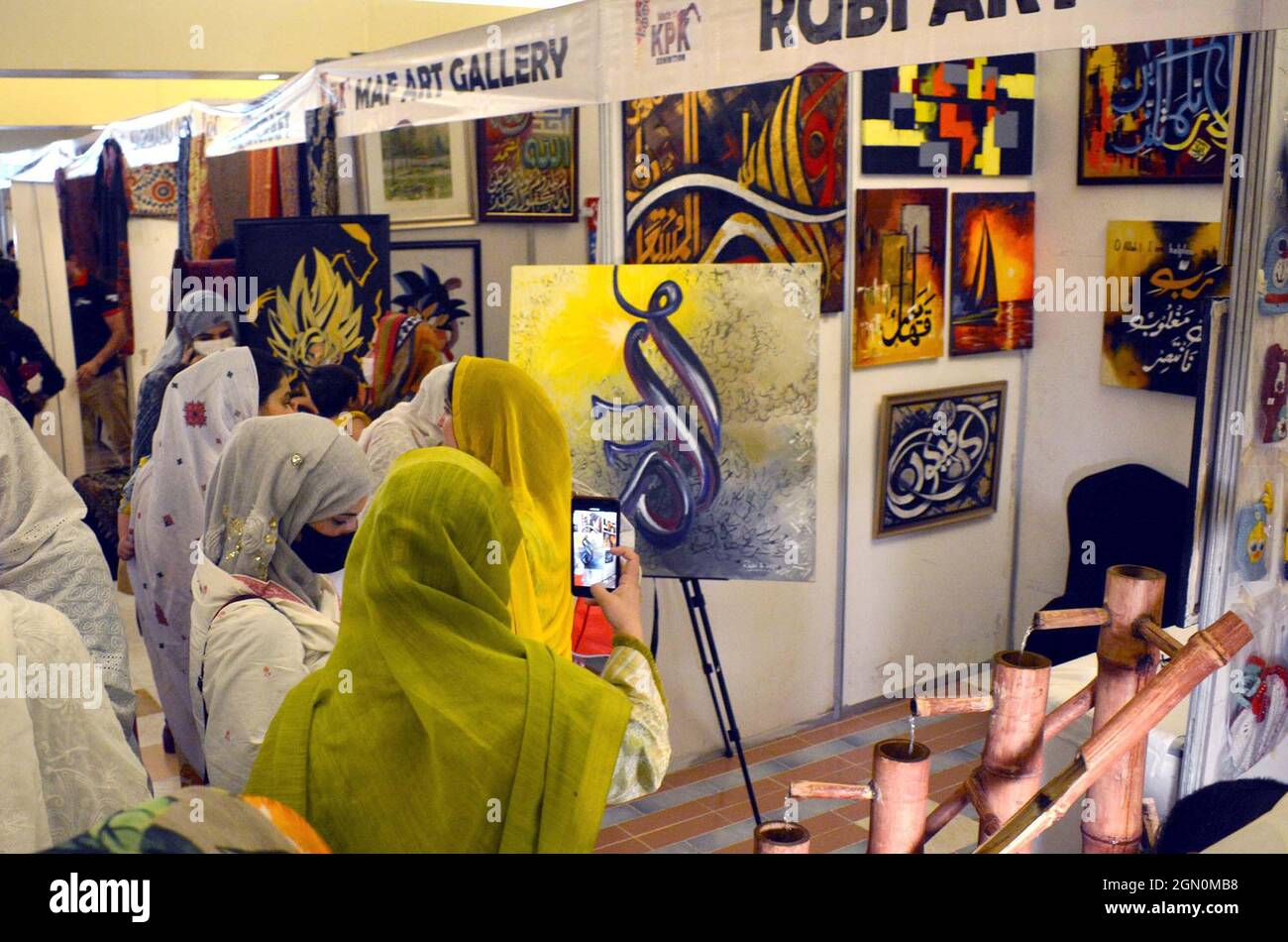 I visitatori si interessano molto alle bancarelle durante il Made in Khyber Pakhtunkhwa Exhibition Expo 2021 organizzato dalla Camera di Commercio e industria delle Donne (WCCI) che si è tenuta a Peshawar martedì 21 settembre 2021. Foto Stock