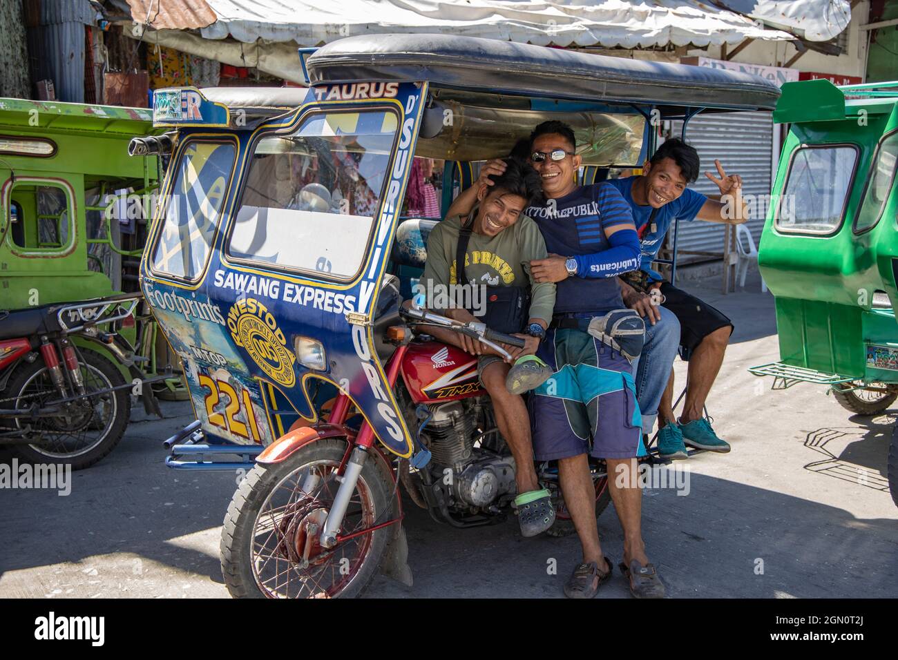 Tre uomini felici aspettano di fronte ad un risciò a tre ruote a Romblon Town, Barangay i, Romblon, Romblon, Filippine, Asia Foto Stock