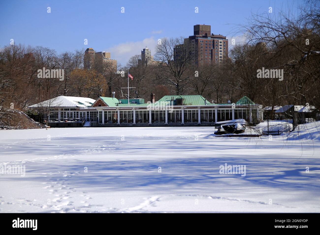 Il lago ghiacciato e la casa di barche in un parco centrale d'inverno a New York City Foto Stock