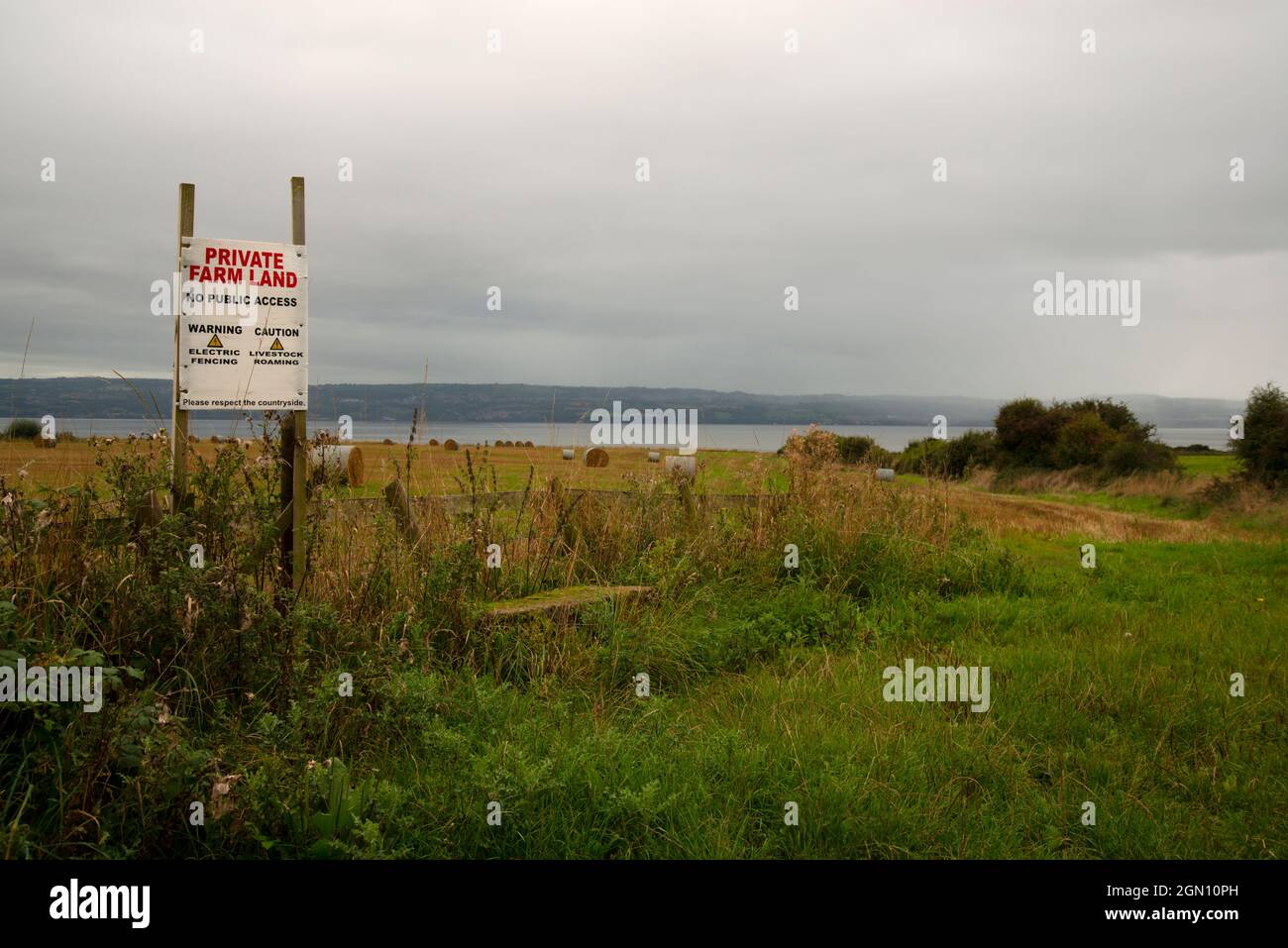 Terreno agricolo sulla penisola di Wirral con un segnale di avvertimento che indica che il terreno è privato e non consente l'accesso pubblico Foto Stock