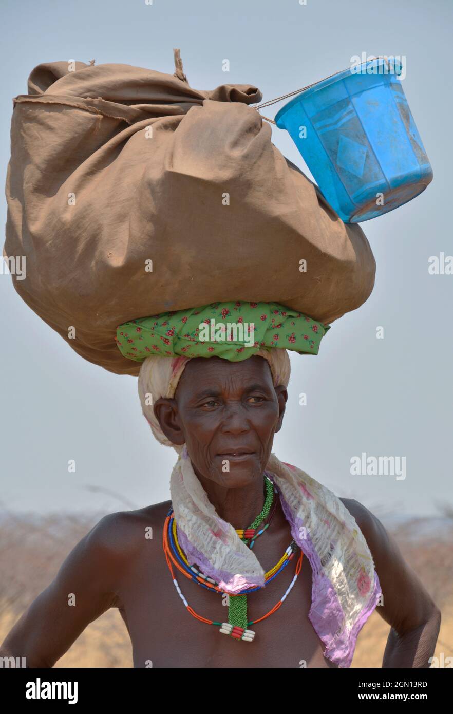 Angola; nella parte occidentale della provincia di Cunene; donna in strada; con bagaglio in testa Foto Stock