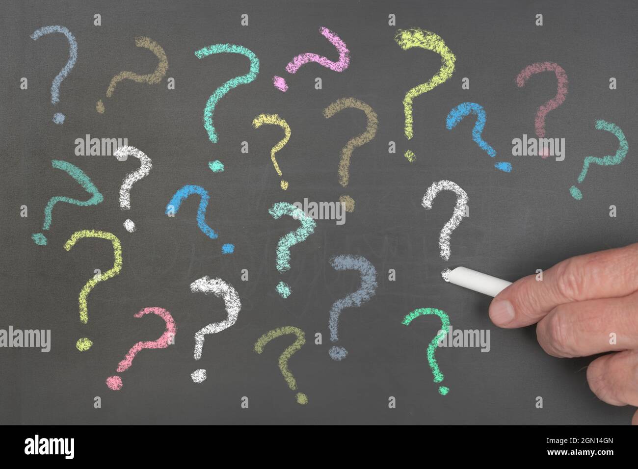 Immagine concettuale di più punti interrogativi scritti su una bacheca con gesso da utilizzare per evidenziare la domanda senza risposta, i messaggi sconosciuti o confusi Foto Stock