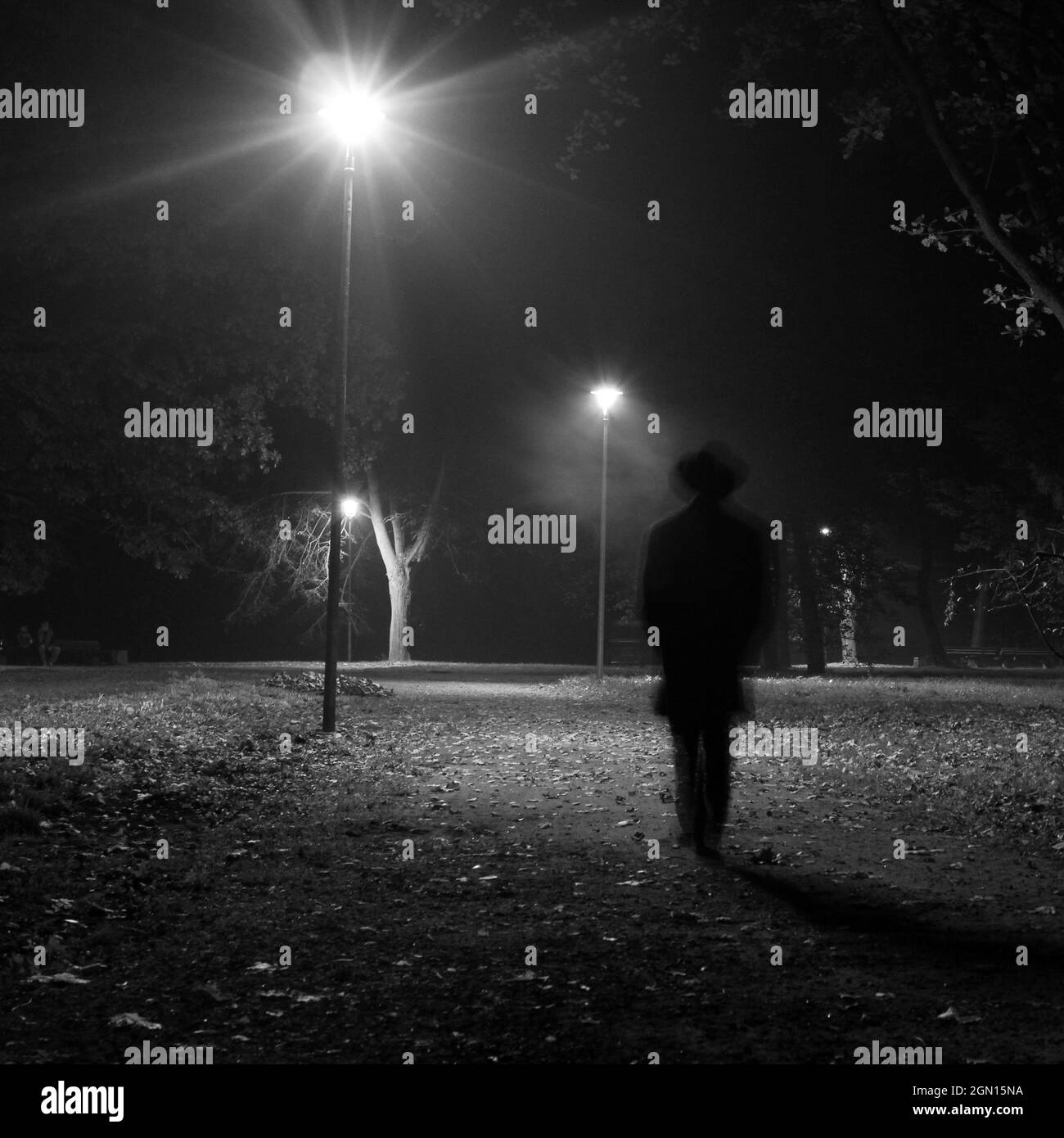Uomo surreale che cammina nel parco di notte. Foto Stock