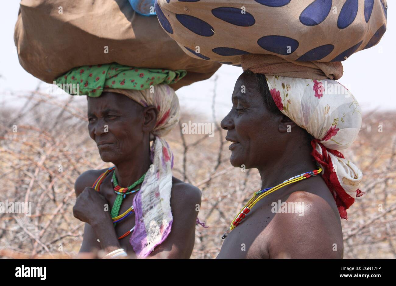 Angola; parte occidentale della provincia di Cunene; due donne a bordo strada; trasporto del bagaglio sulla testa Foto Stock
