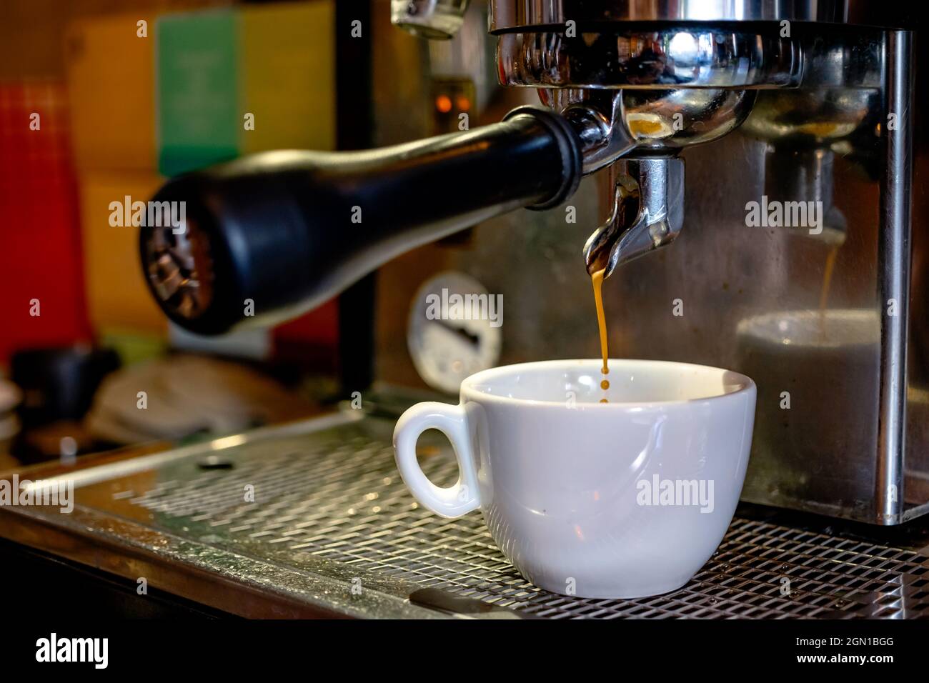 Preparazione di una tazza di espresso con una macchina da caffè  professionale. Primo piano su una tazza bianca e un caffè caldo versato da  una macchina Foto stock - Alamy