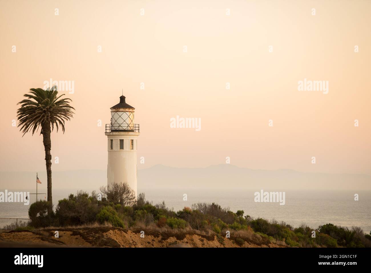 Casa di luce e palma su una scogliera da vicino Foto Stock
