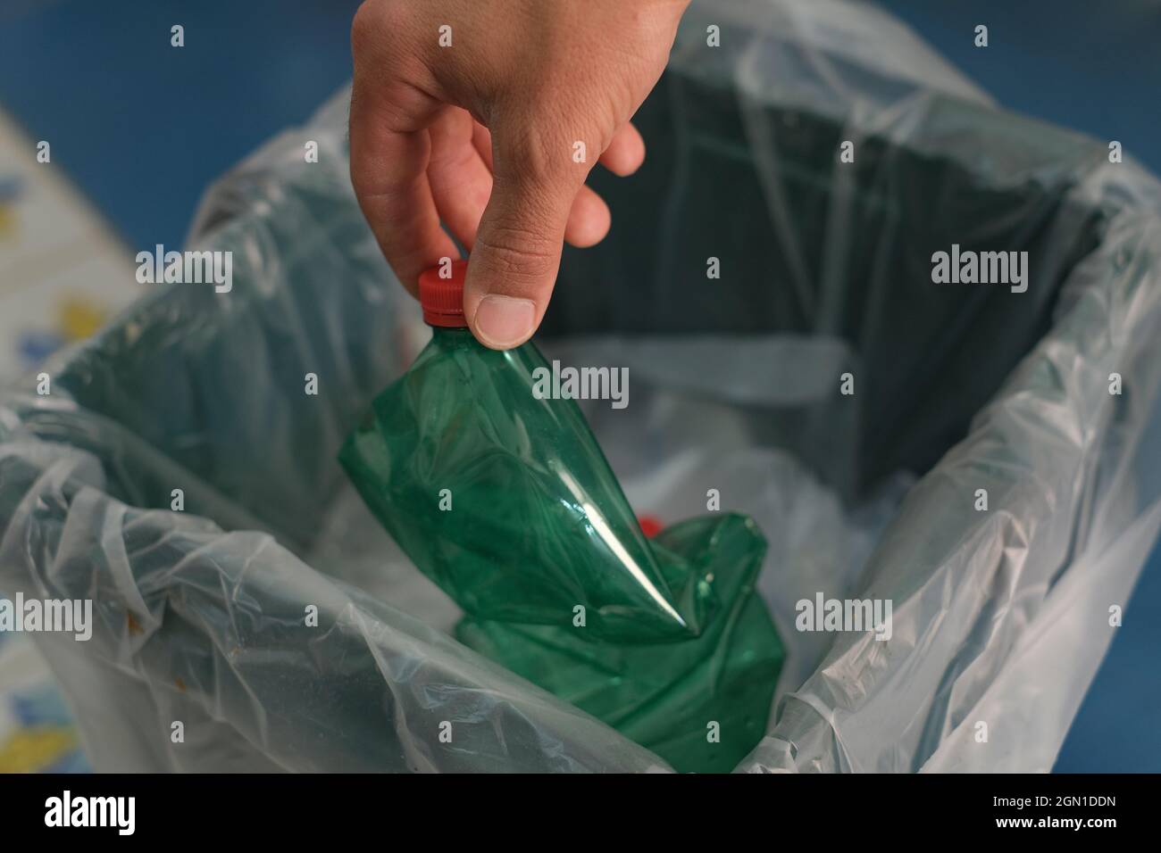 Man mano cestino utilizzato bottiglia di plastica su bidone separato raccolta rifiuti, riciclaggio Foto Stock