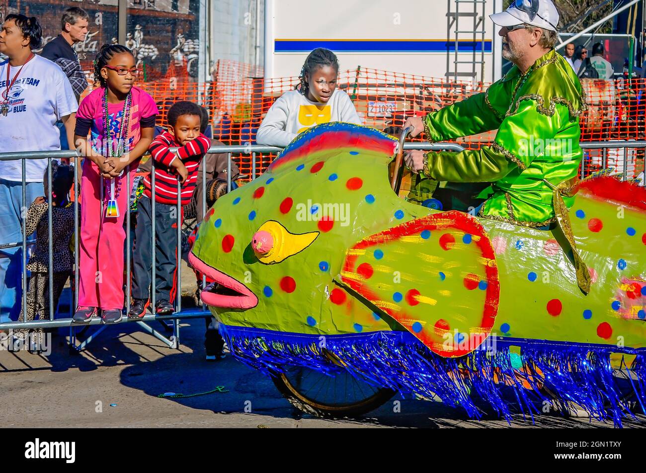I bambini guardano un galleggiante Mardi Gras a forma di pesce montato su una bicicletta durante la parata del Joe Cain Day Mardi Gras, 7 febbraio 2016, a Mobile, Alabama. Foto Stock