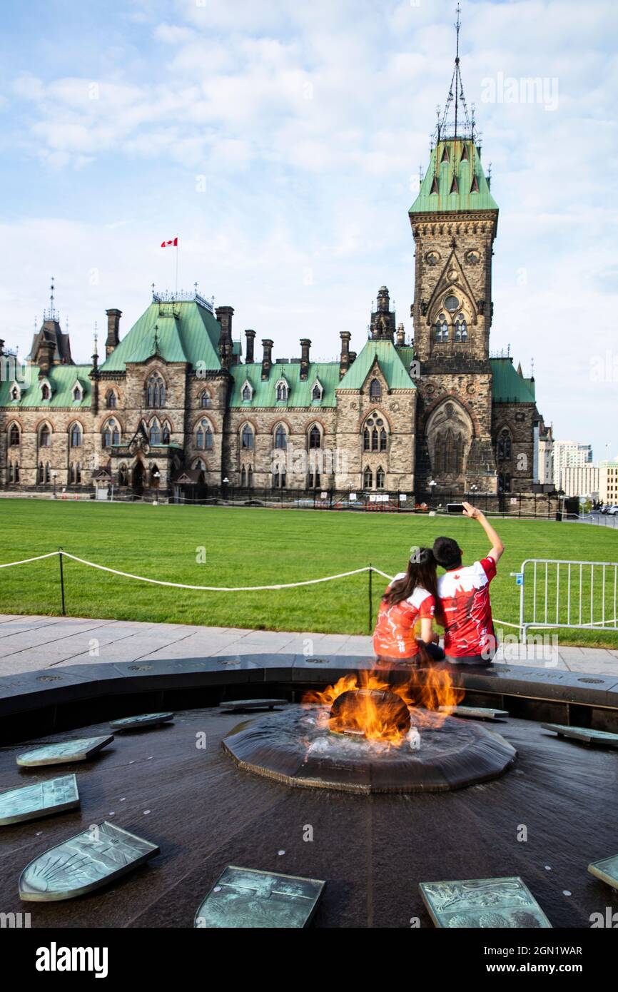 I turisti fotografano selfie con la fiamma Eterna di fronte al Palazzo del Parlamento, Ottawa, Ontario, Canada, Nord America Foto Stock