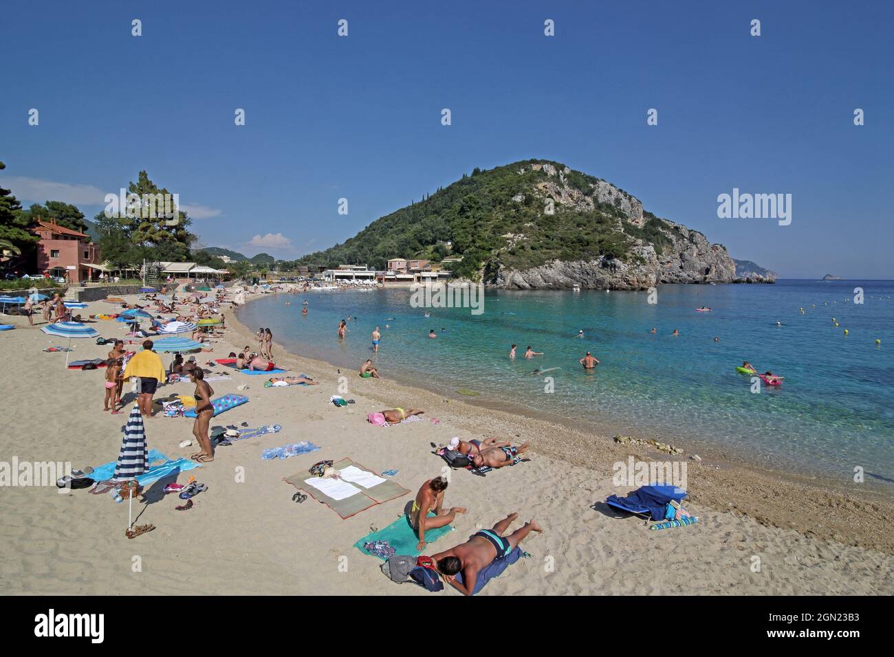 La spiaggia di Agios Spiridon di Paleokastritsa, per lo più sabbiosa, si estende tra due penisole e sotto il monastero di Panagia Theotokou, l'isola di Corfù, Ioni Foto Stock