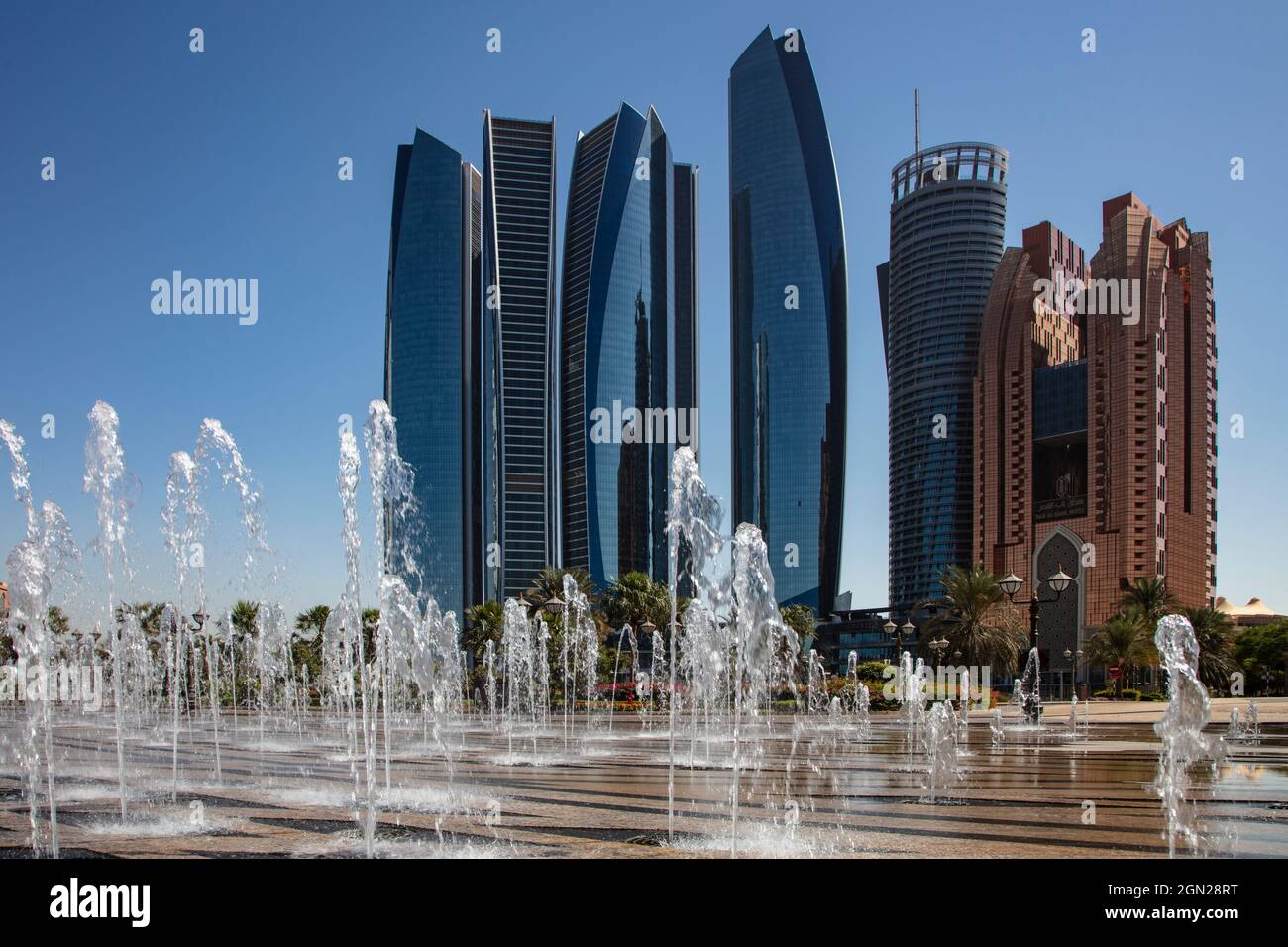 Grattacieli visti dalla fontana sotto l'Emirates Palace Hotel, Abu Dhabi, Abu Dhabi, Emirati Arabi Uniti, Medio Oriente Foto Stock