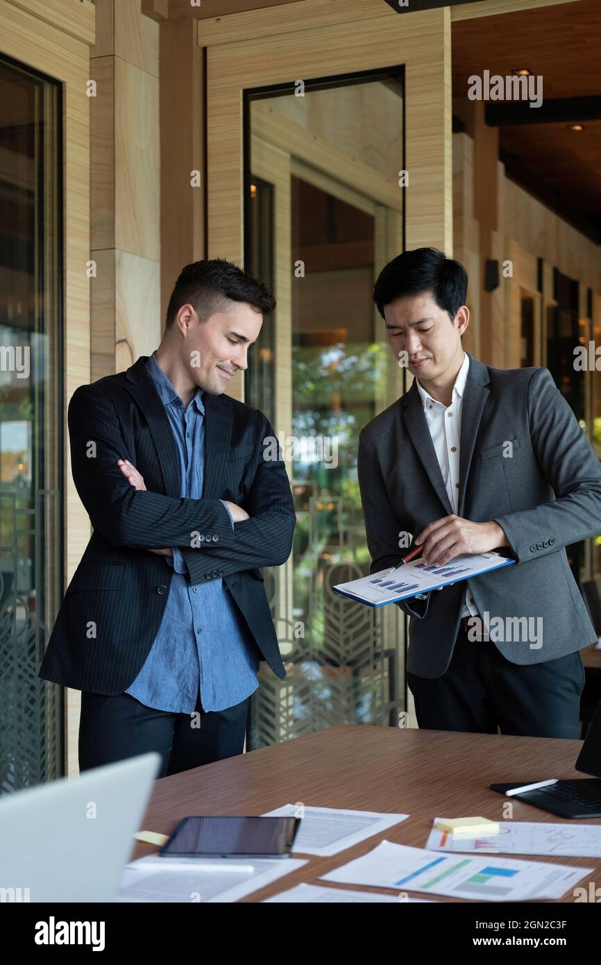 Persona d'affari presente ad investitore professionale che lavora nuovo progetto di start up. I responsabili finanziari incontrano e discutono dei dati di analisi sui grafici Foto Stock