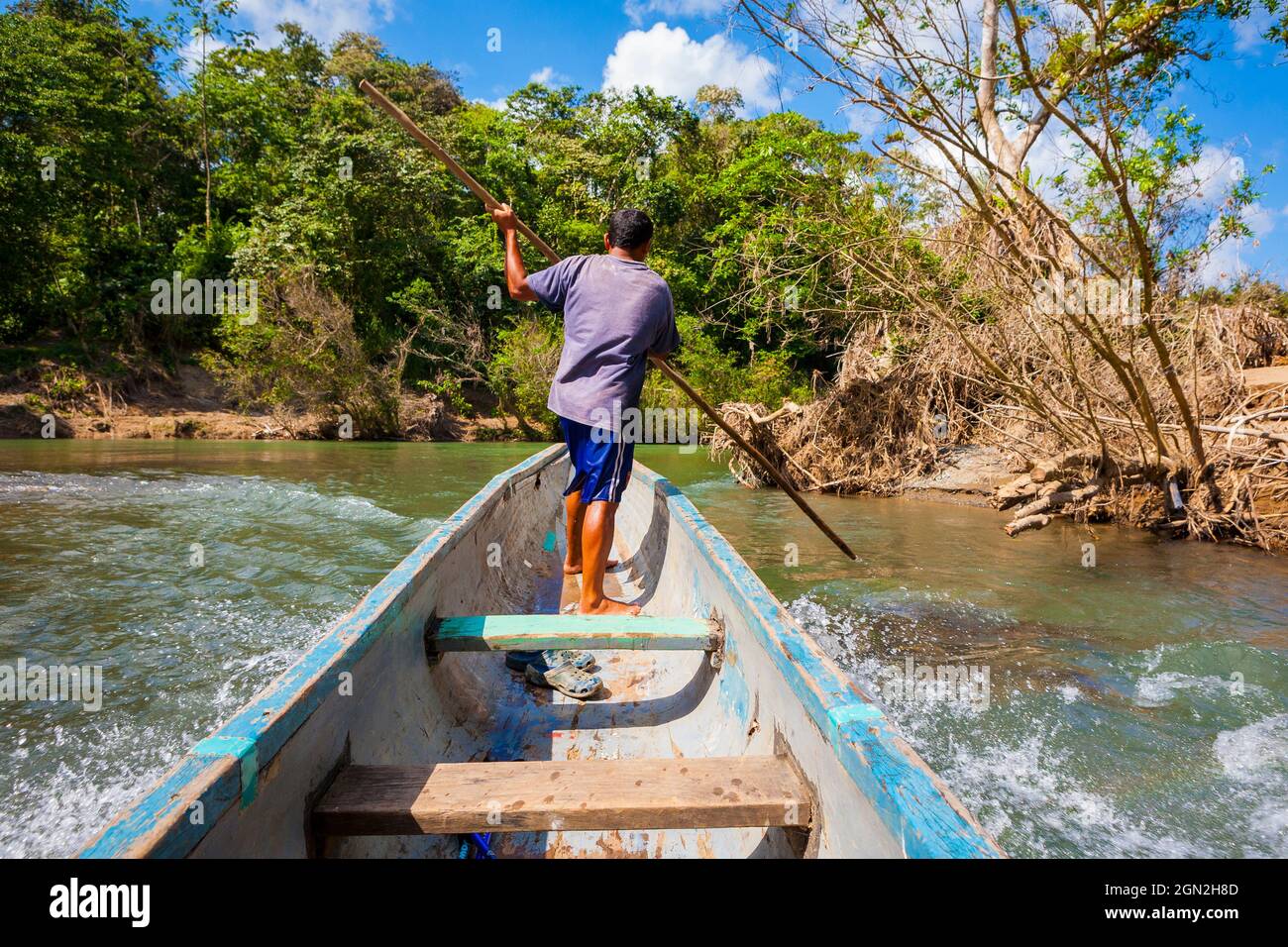 Un uomo panamense in una canoa in dugotta sta viaggiando verso l'alto Rio Pequeni, parco nazionale di Chagres, Repubblica di Panama, America Centrale. Foto Stock