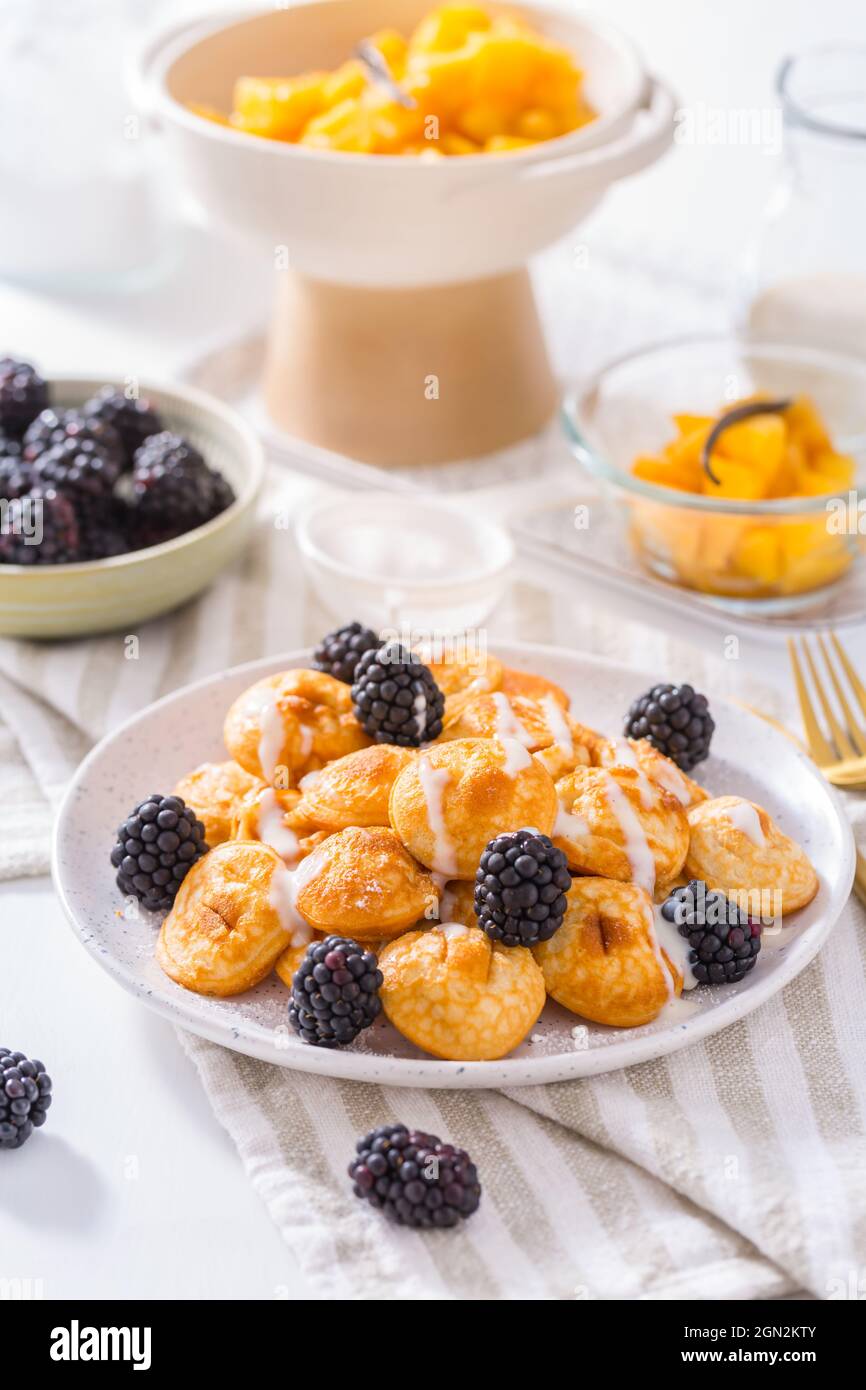 Mini pancake olandesi chiamati poffertjes con more e compot di mele Foto Stock