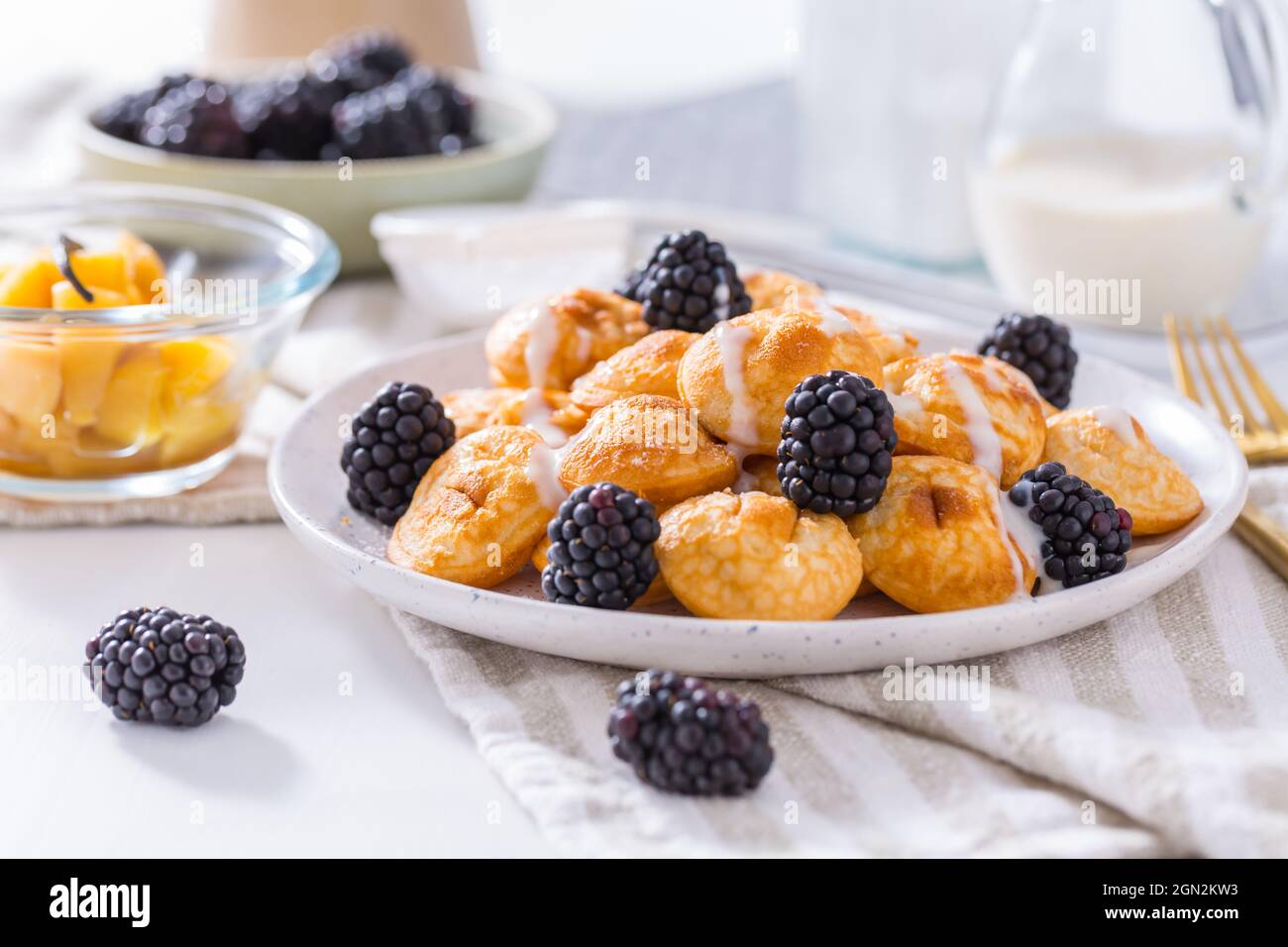 Mini pancake olandesi chiamati poffertjes con more e compot di mele Foto Stock