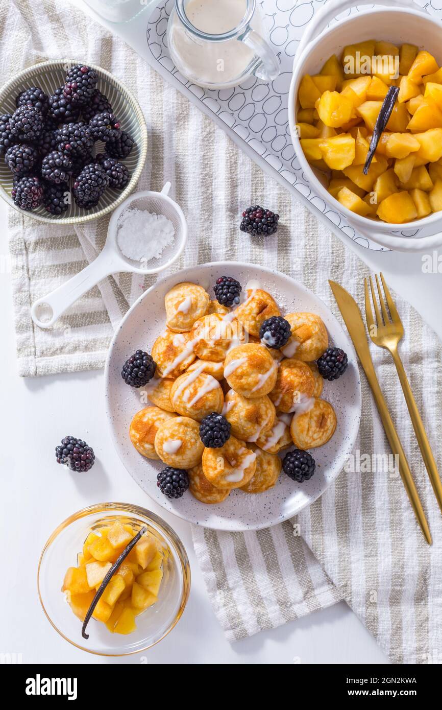 Mini pancake olandesi chiamati poffertjes con more e compot di mele Foto Stock