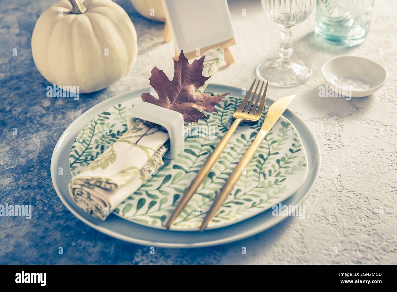 Luogo per il Ringraziamento in stile vintage con zucche e foglie d'autunno Foto Stock