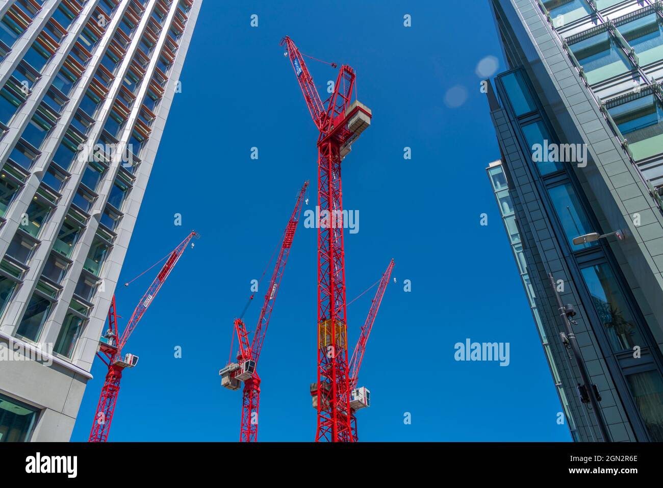 Vista delle gru rosse contro il cielo blu, Città di Londra, Londra, Inghilterra, Regno Unito, Europa Foto Stock