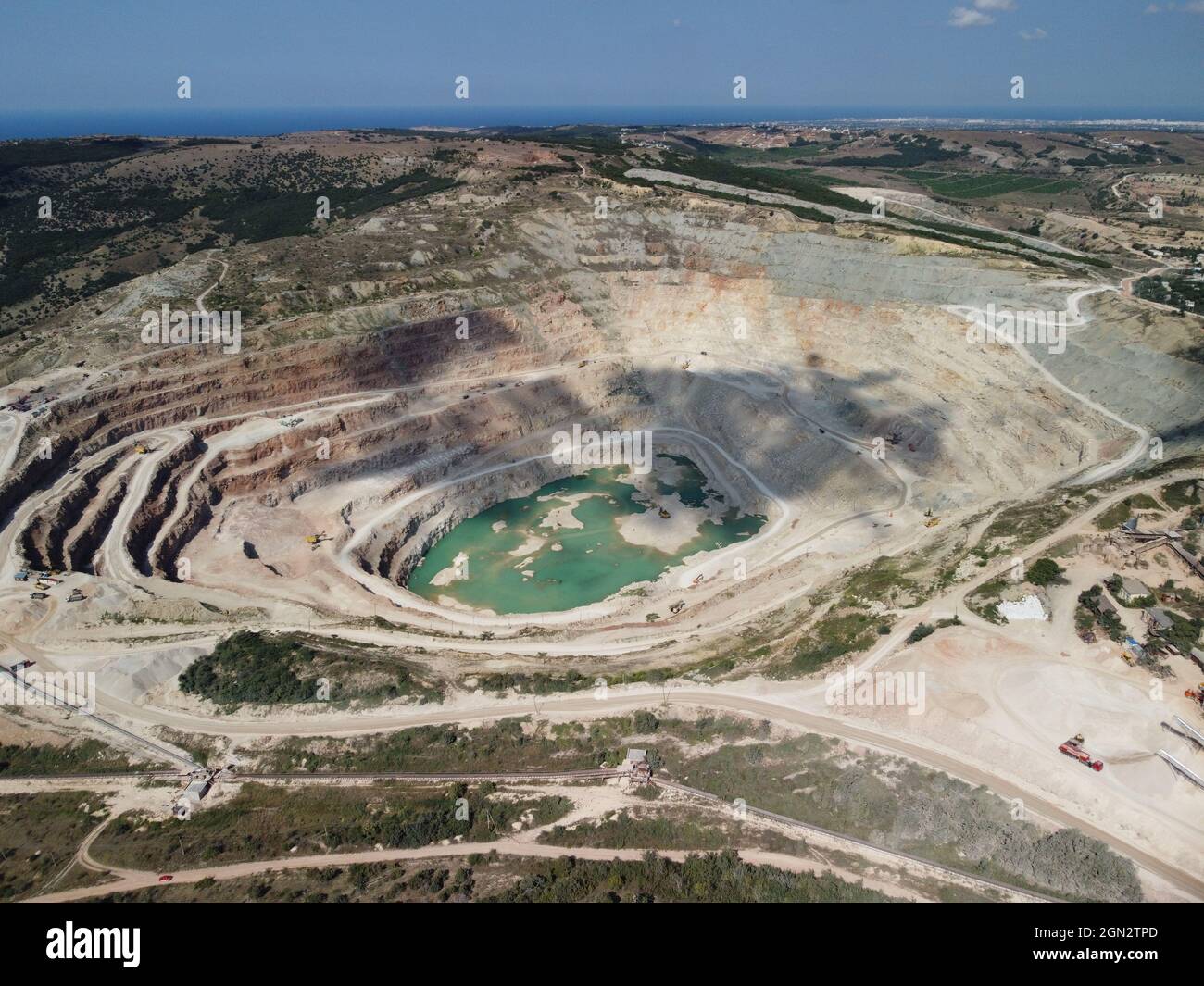 Vista aerea industriale di cave di opencast con molti macchinari in funzione - estrazione di flussi per l'industria metallurgica. Settore minerario ovale Foto Stock