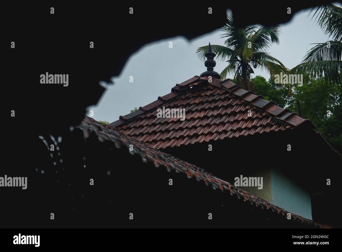 Caduta di pioggia dalle vecchie tegole del tetto Foto Stock