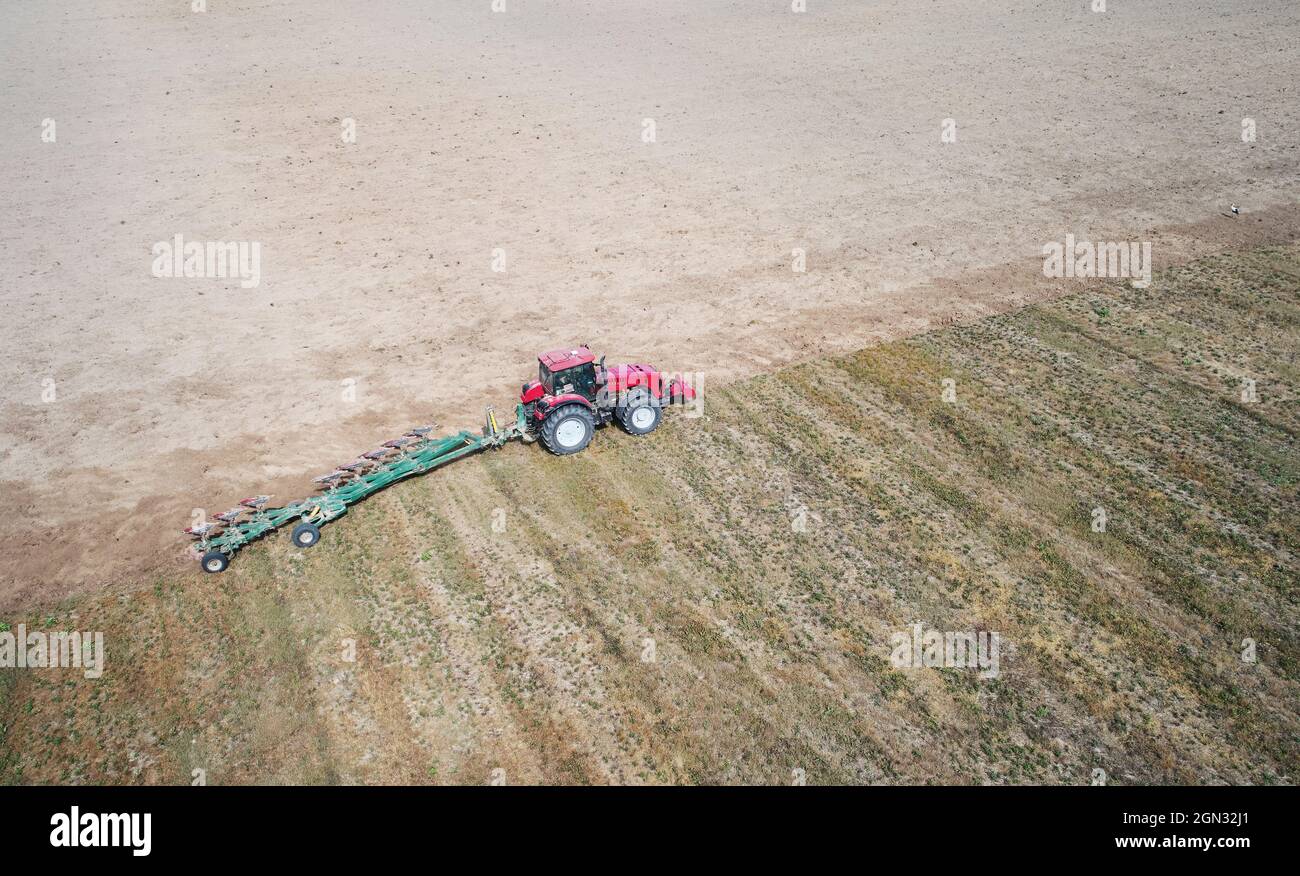Vista del drone dell'antenna del campo di aratura del trattore. Tema agricolo Foto Stock