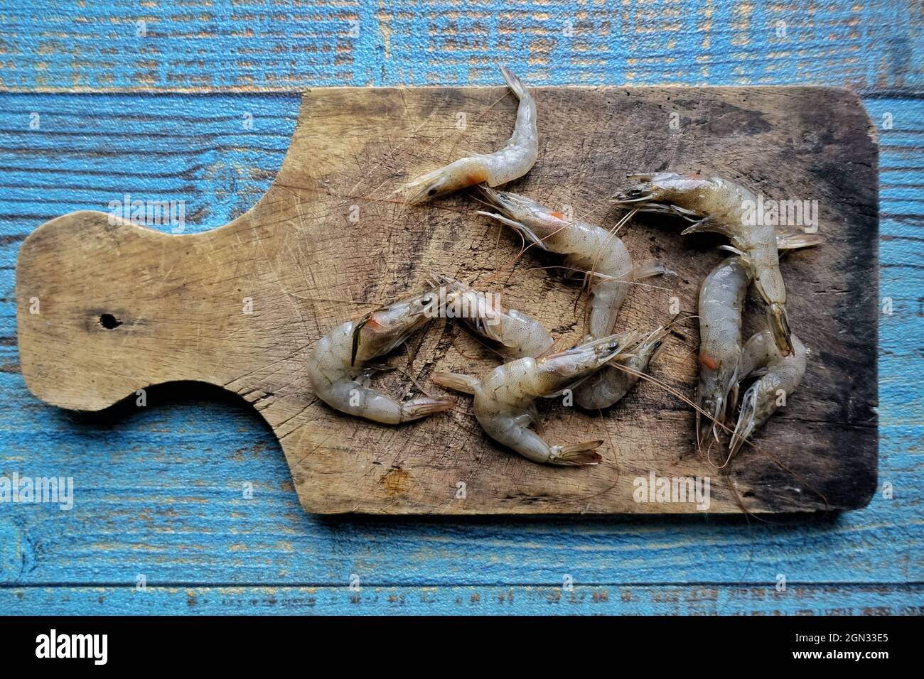 mazzo di gamberi crudi pronti a friggere su sfondo di legno Foto Stock