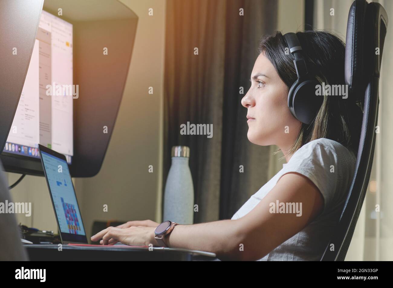 Lavorare in remoto a casa utilizzando un notebook e un grande schermo Foto Stock
