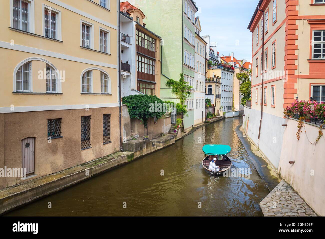 Certovka, barca da crociera con turisti che navigano tra gli edifici sul canale d'acqua nella città piccola, Praga, Repubblica Ceca Foto Stock
