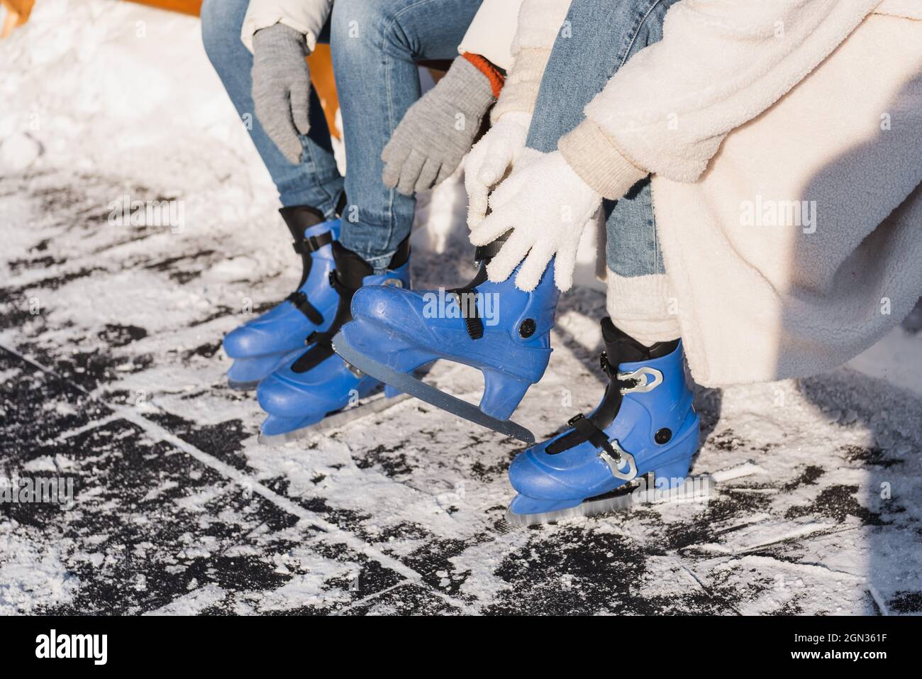 vista ritagliata di coppia che indossa pattini da ghiaccio Foto Stock