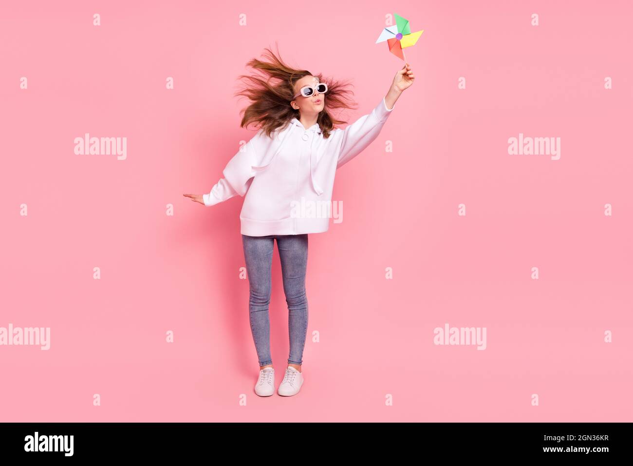 Vista completa del corpo della ragazza allegra di gioco di carta pin ruota pout labbra isolate su sfondo rosa pastello colore Foto Stock