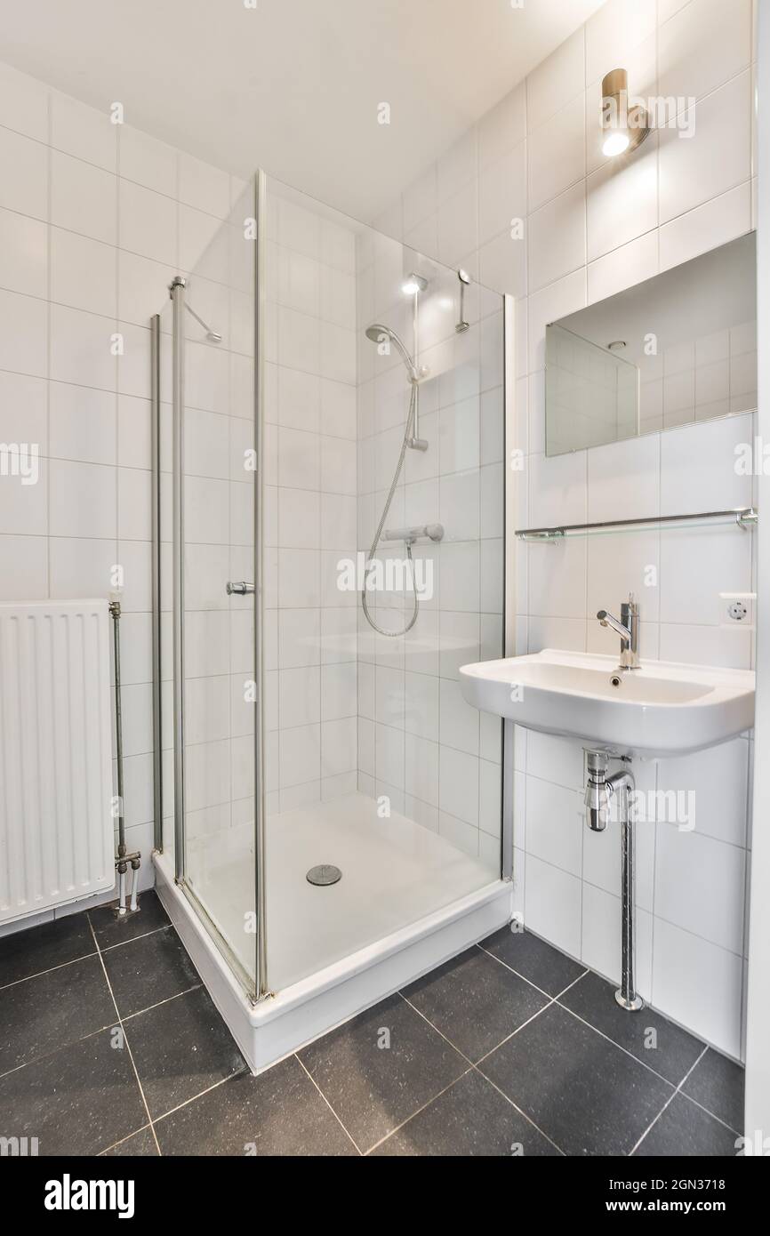 Interno del bagno di casa con specchio appeso sul lavandino posto vicino  porta di ingresso e cabina doccia in vetro in appartamento moderno Foto  stock - Alamy