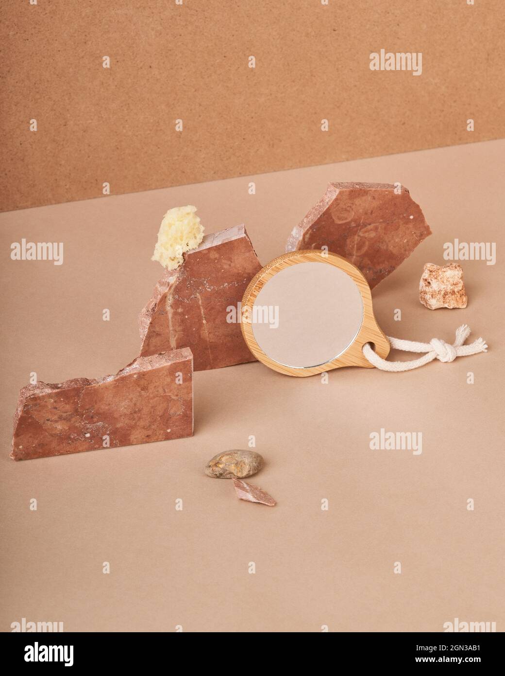 Saponette naturali con spugna vicino allo specchio in una cornice ecologica su sfondo beige Foto Stock